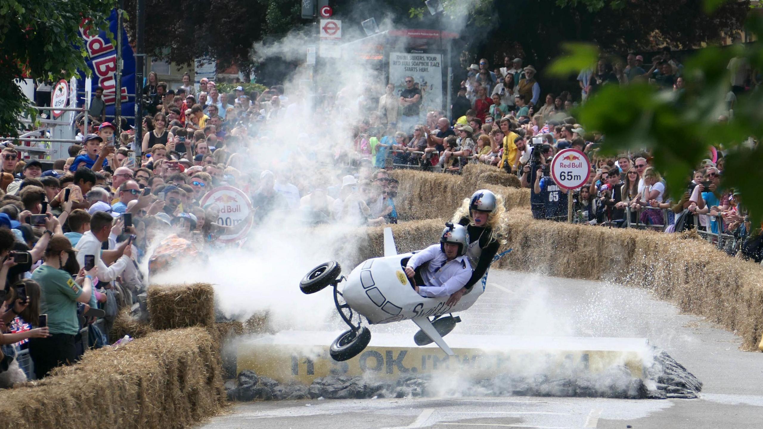 Spectators at Alexandra Palace in London watch Swifty Air, a soapbox inspired by Taylor Swift, lose control on the course and head towards the haybales