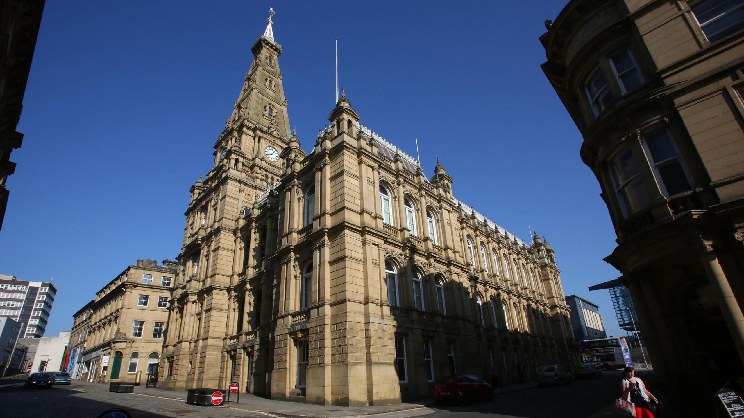 The front of Halifax Town Hall including its clock tower, with clear blue sky above.