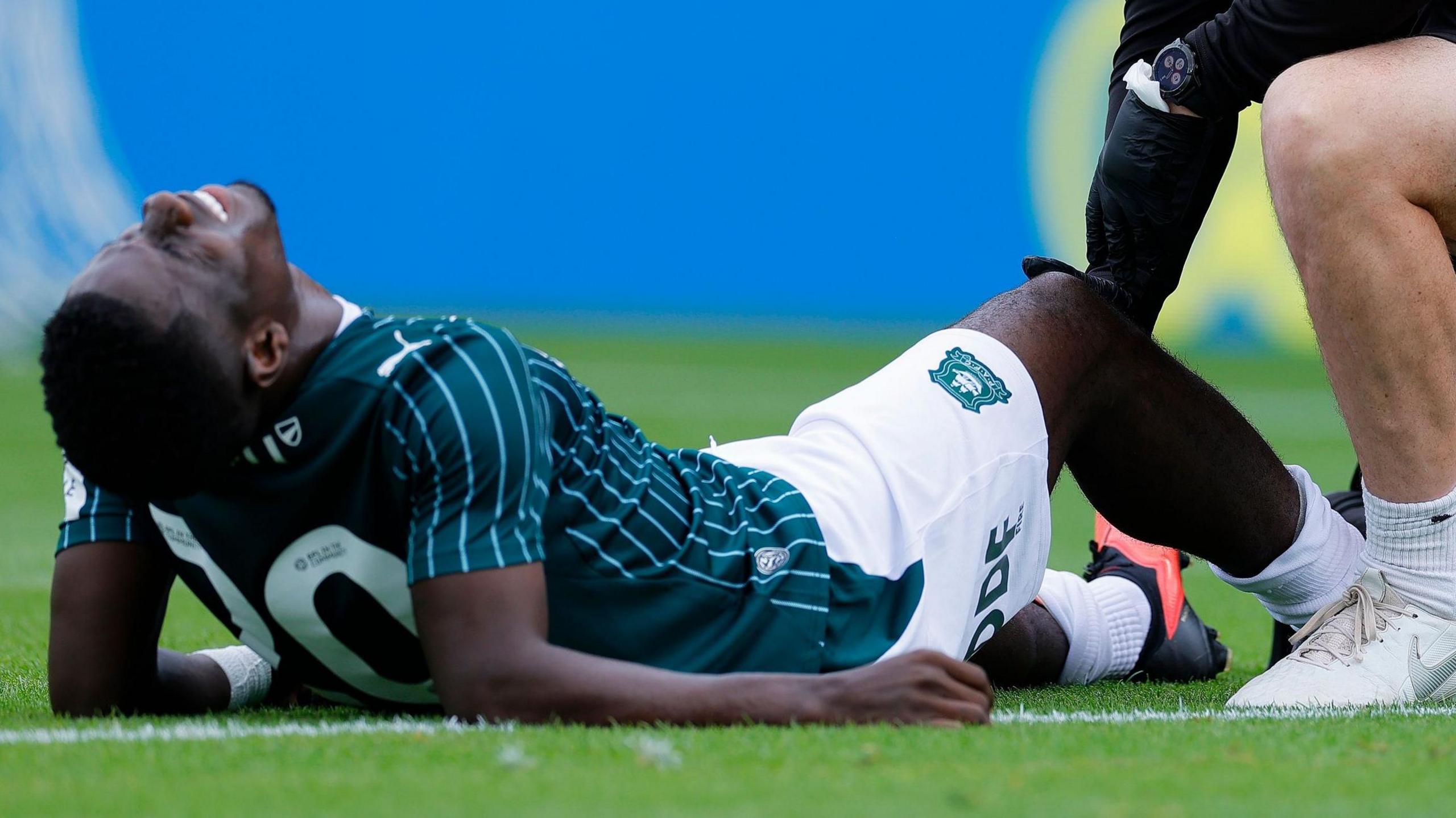 Michael Baidoo lies on the field injured