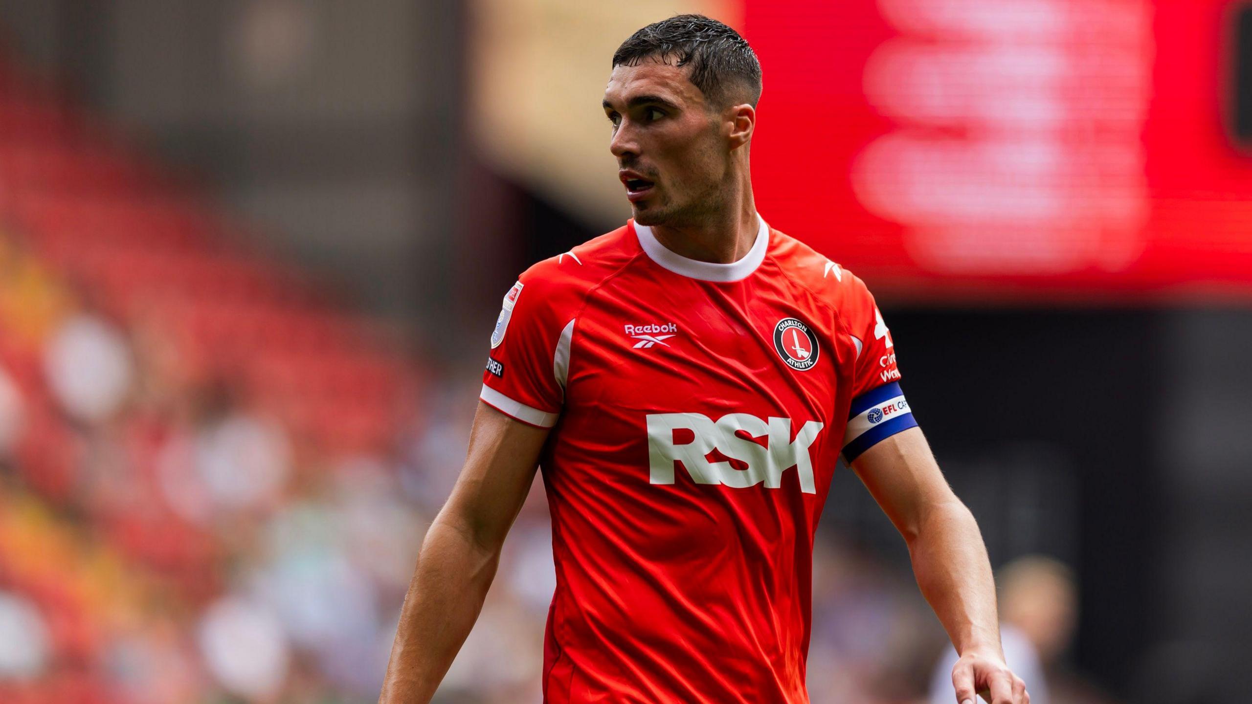 Lloyd Jones looks round while playing for Charlton Athletic in his red home kit during their match against Derby County