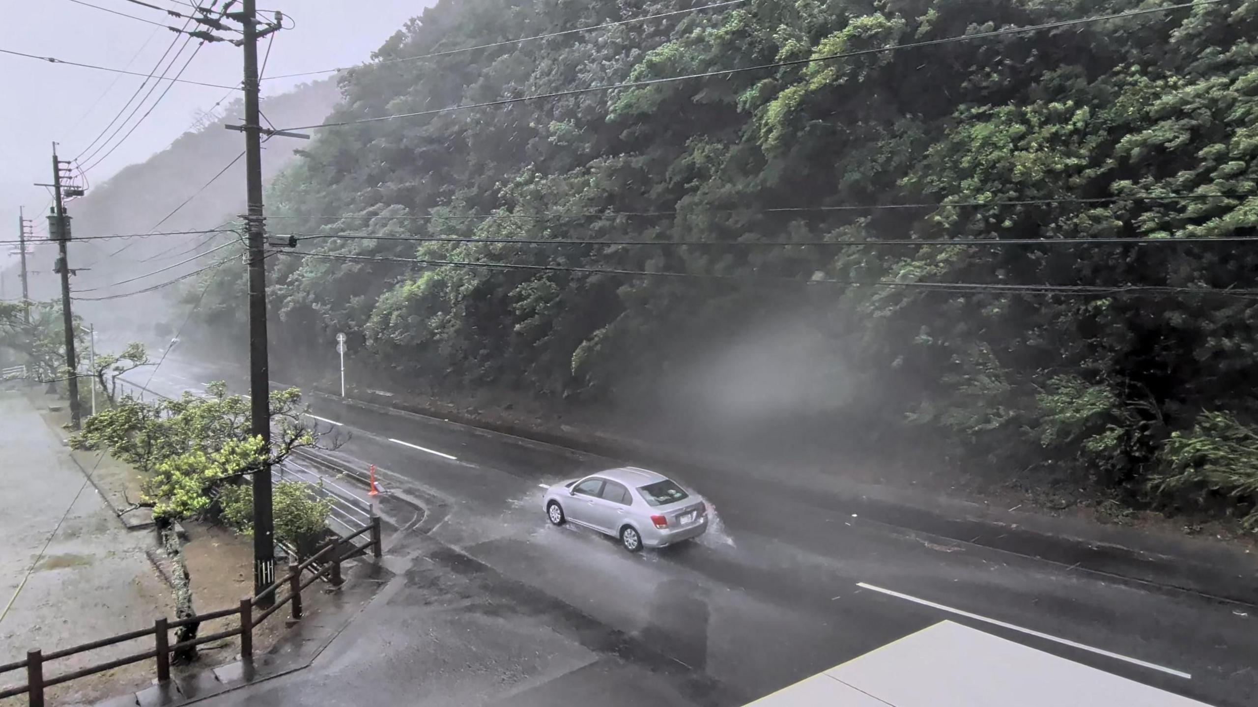 A car makes its way through strong winds and rain as Typhoon Dolphin approaches, in Nazeasahicho, Amami, Kagoshima, Japan, August 7, 2026, in this screengrab obtained from a social media video. 
