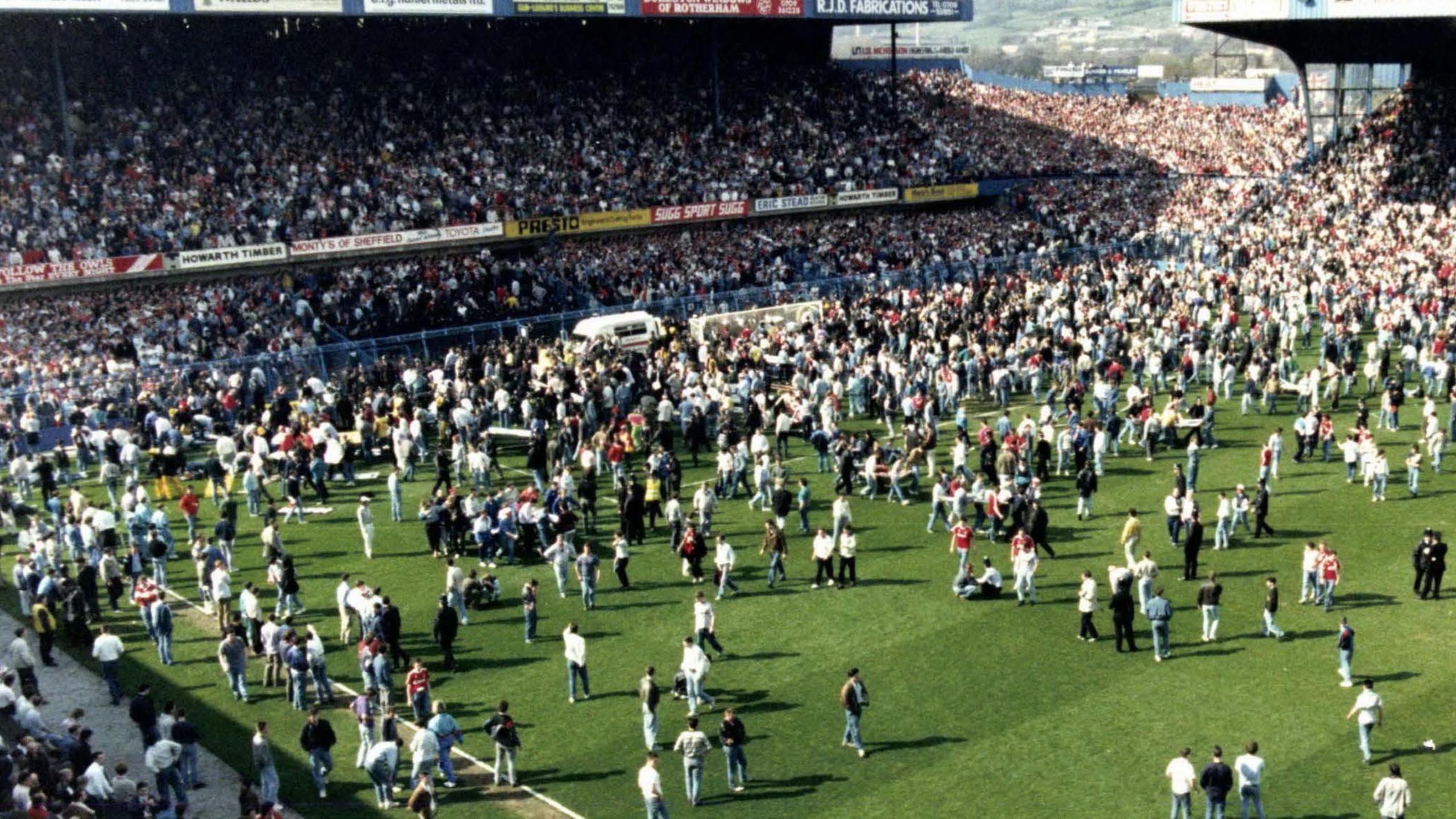 Fans on the pitch after a crush at the Hillsborough ground in 1989