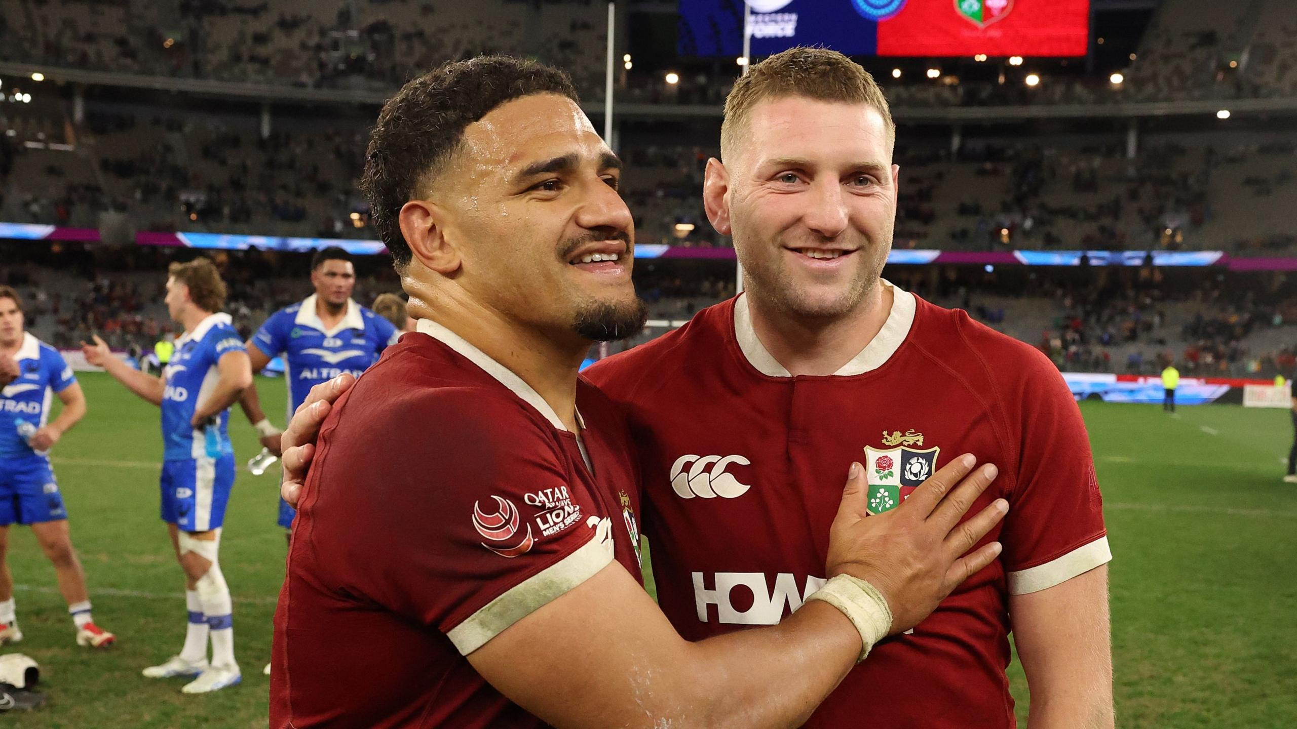 Sione Tuipulotu and Finn Russell celebrate on the pitch after the Lions beat Western Force