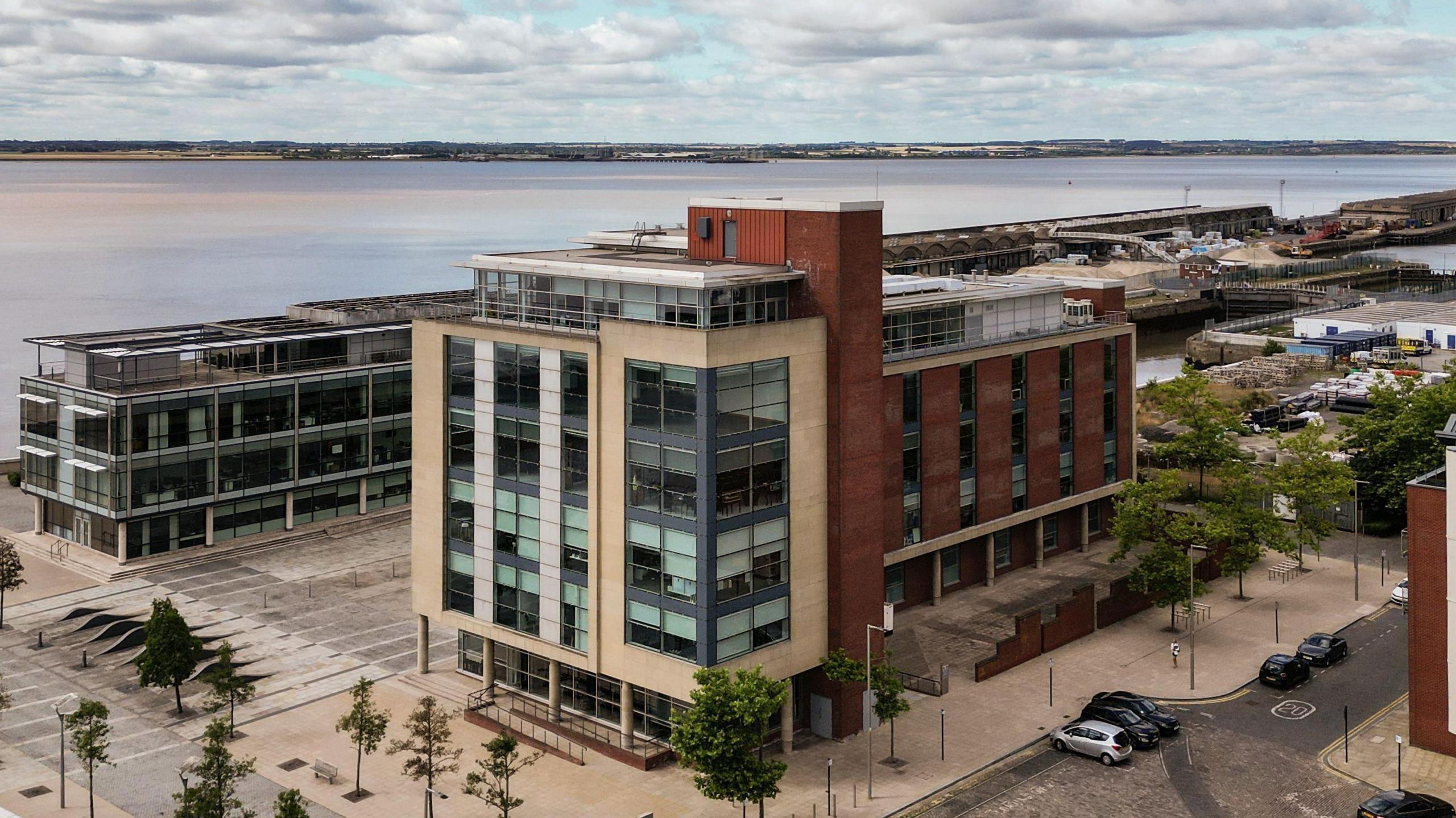 A drone shot of Two Humber Quays - a modern building by the Humber Estuary and the Marina.