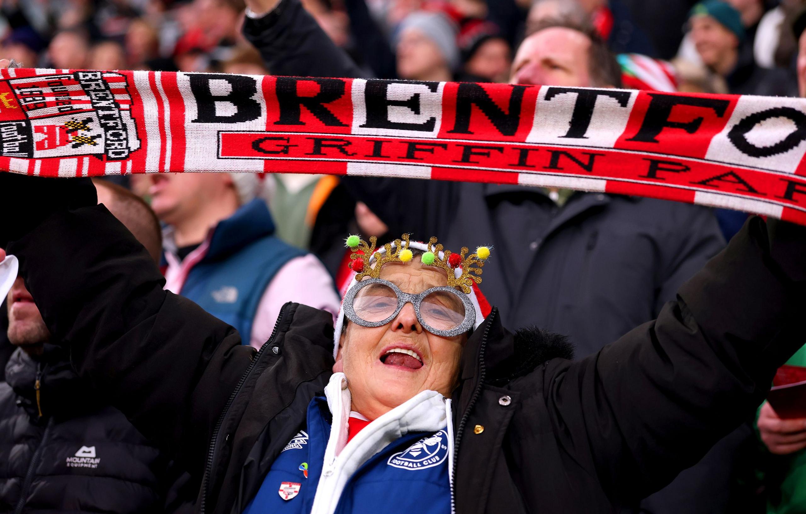 A fan of Brentford holds up a scarf in the stands prior to the Premier League match between Brentford and Nottingham Forest at Gtech Community Stadium