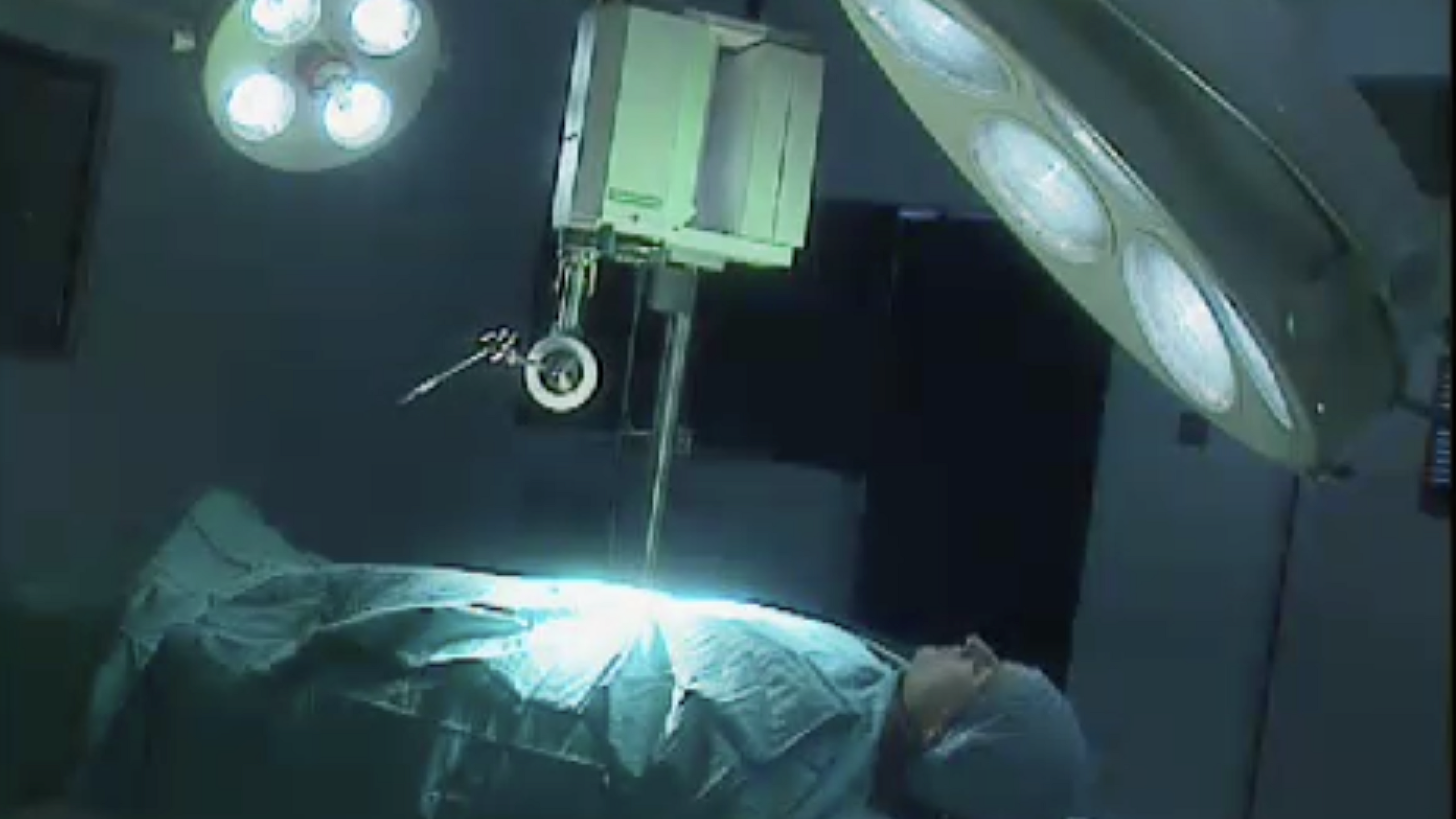 A robot operating on a patient on a hospital bed