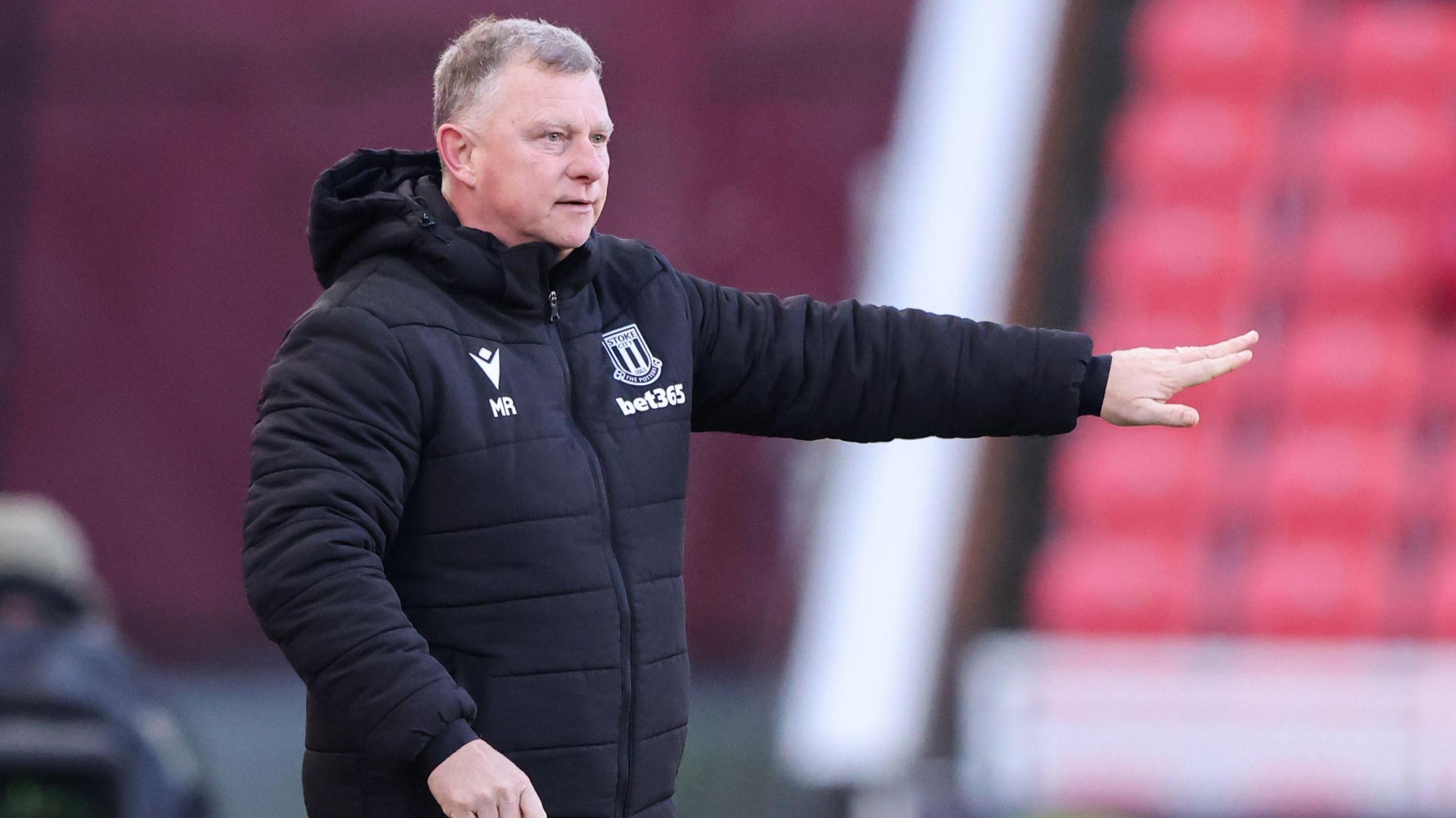 Mark Robins points out some instructions from the touchline during a Stoke City match