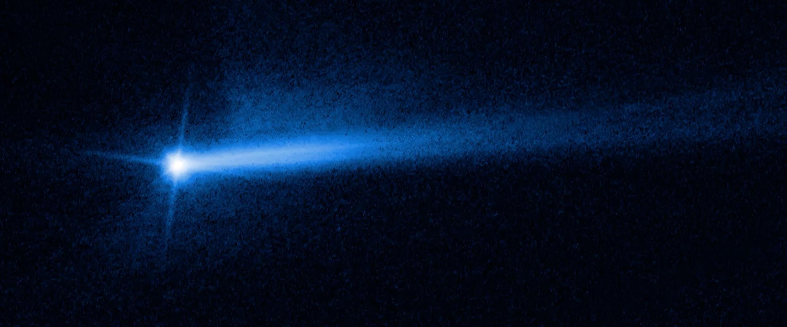 A glowing blue ball in space with a fainter blue trail.