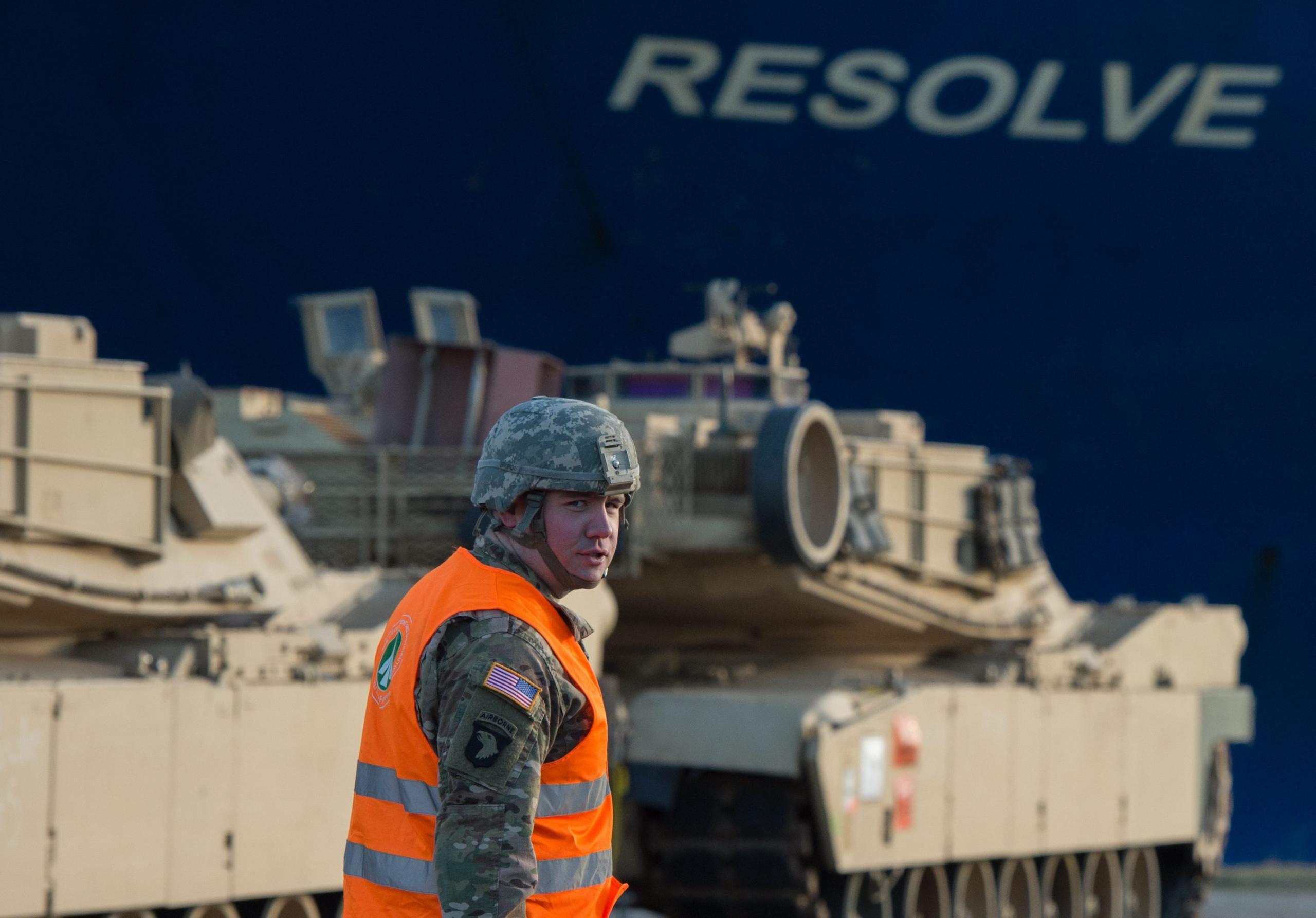 A US soldier walks in front of US Army tanks and the cargo vessel "Resolve" in Bremerhaven, northern Germany