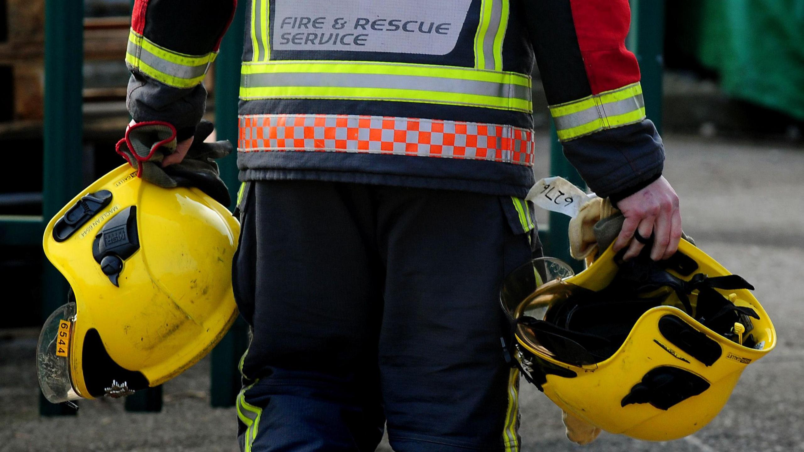 File image of a fire officer holding helmets