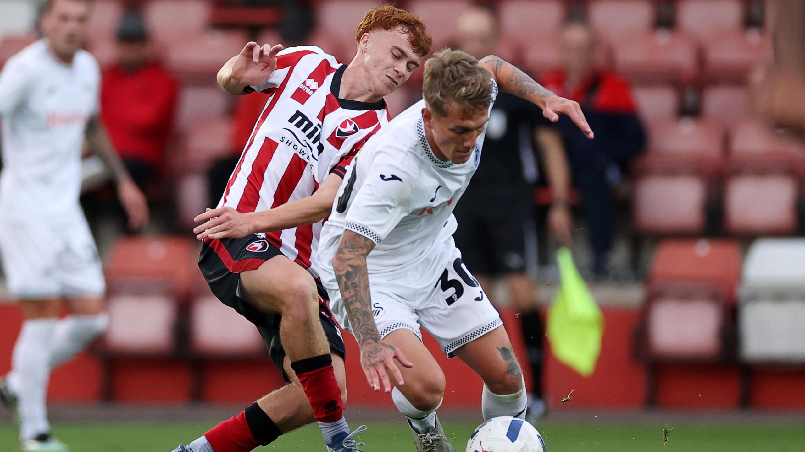 Ethan Galbraith of Swansea City is tackled by Harry Tustin of Cheltenham Town