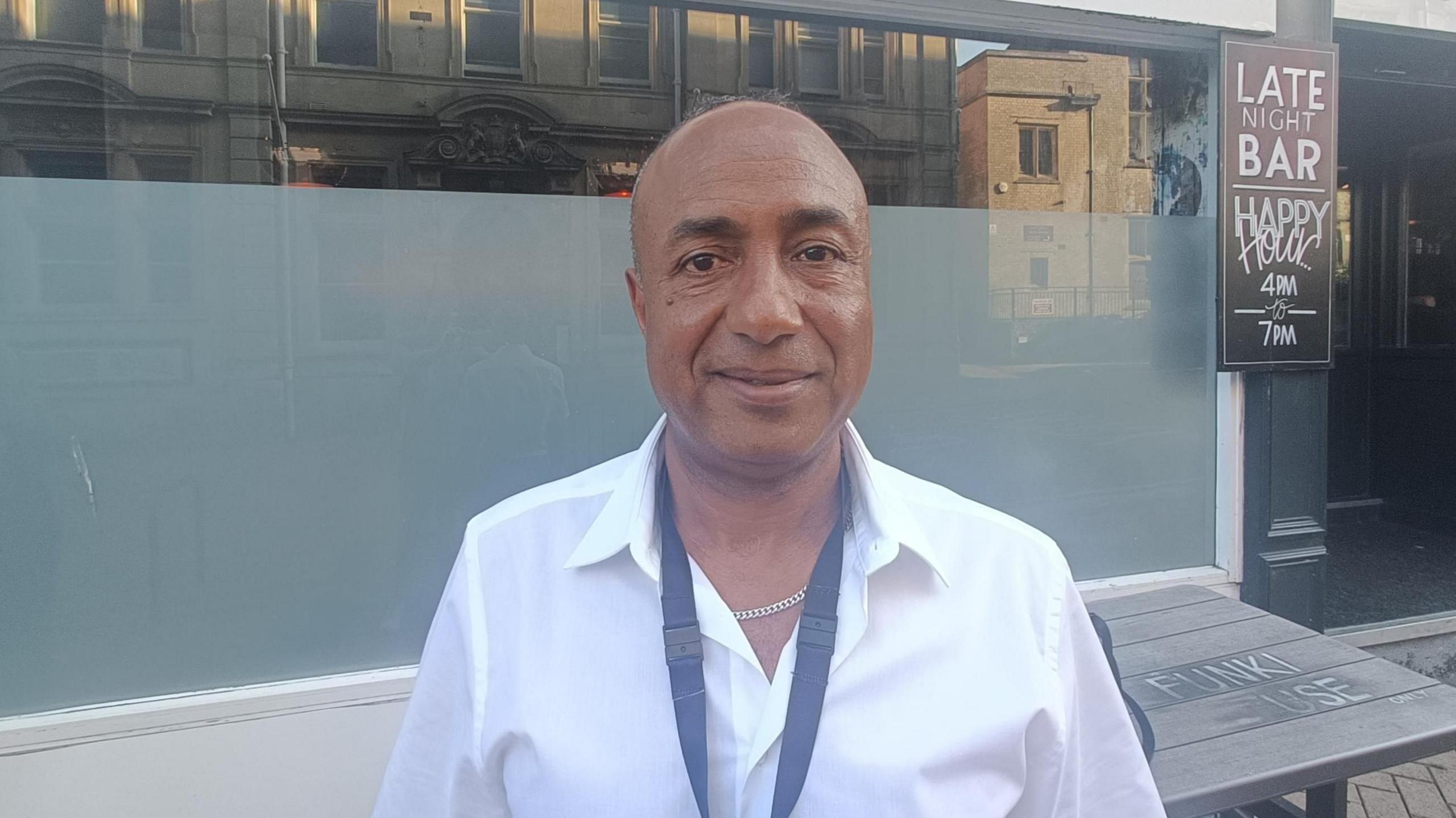 Ben Maatoug is a Personal Advisor with Bournemouth Christchurch and Poole (BCP) Council, looking towards a camera wearing a white shirt and a black lanyard.