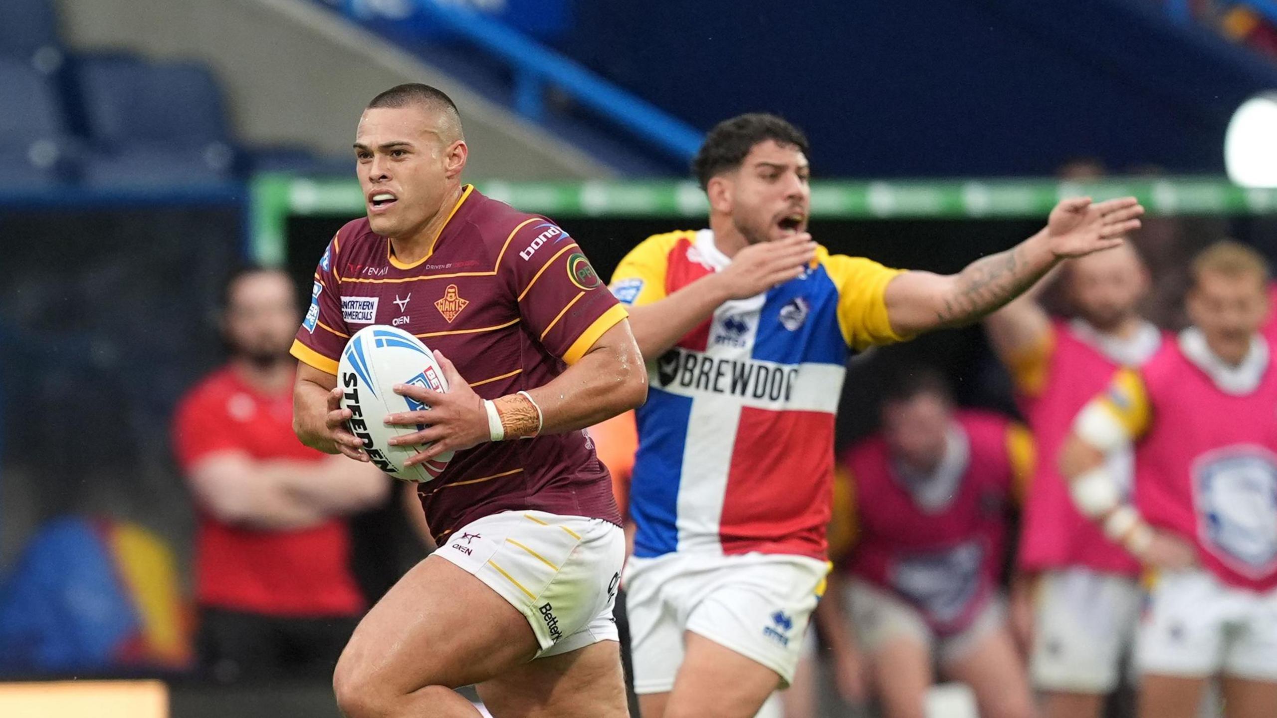 Tui Lolohea races away for a Huddersfield Giants try