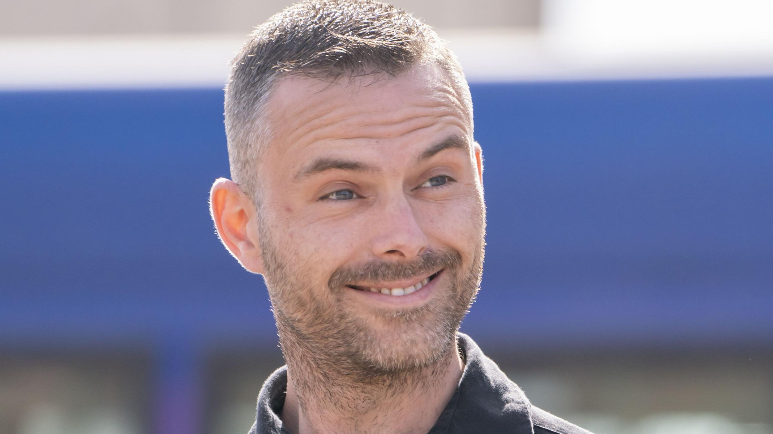 James Fitzgerald, who has short light brown hair, grins at the camera 