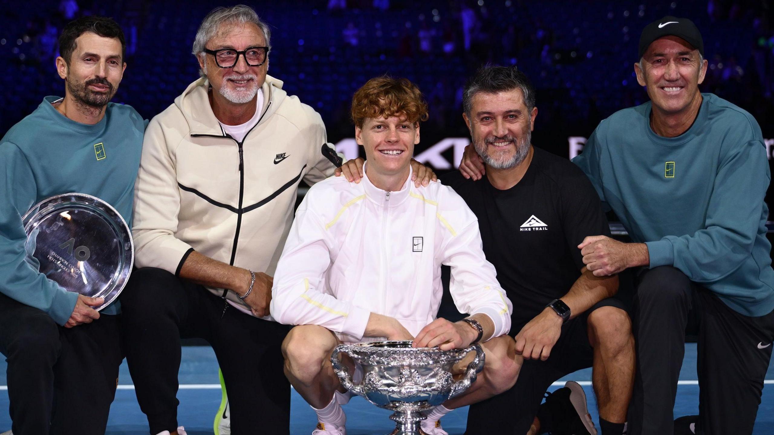 Jannik Sinner poses for a photo with the Australian Open trophy and his team