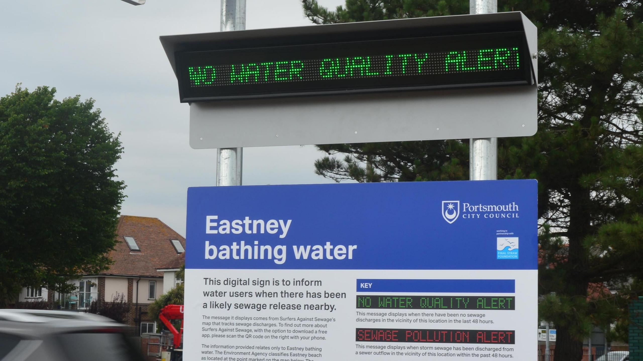 A close-up picture of the electronic sign, which says 'no water quality alert' in green writing, and the sign below it titled 'Eastney bathing water' which explains how the digital display works.