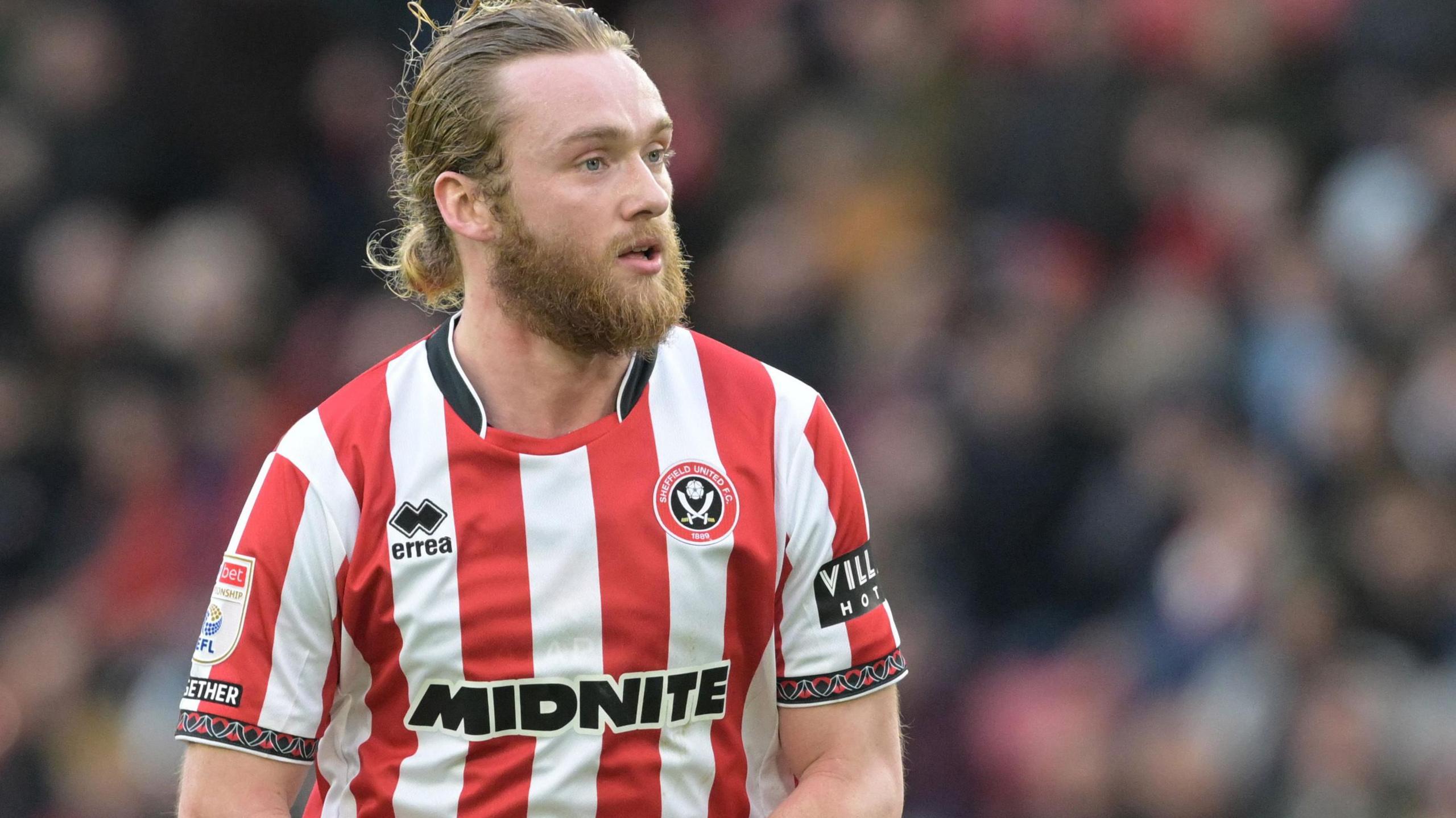 Tom Davies in action for Sheffield United in the club's red and white striped home jersey