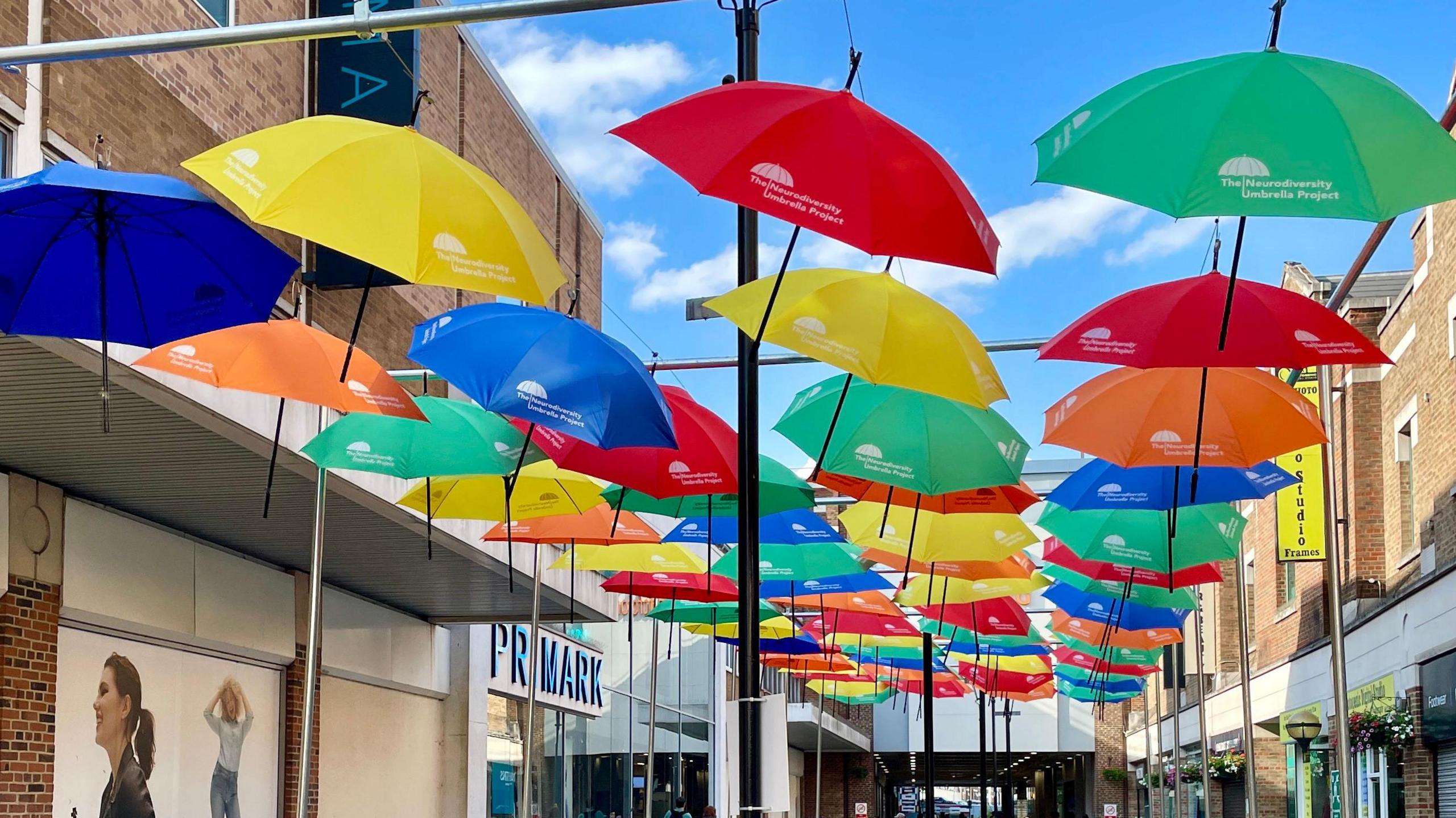 Colourful umbrellas being put in place on a street