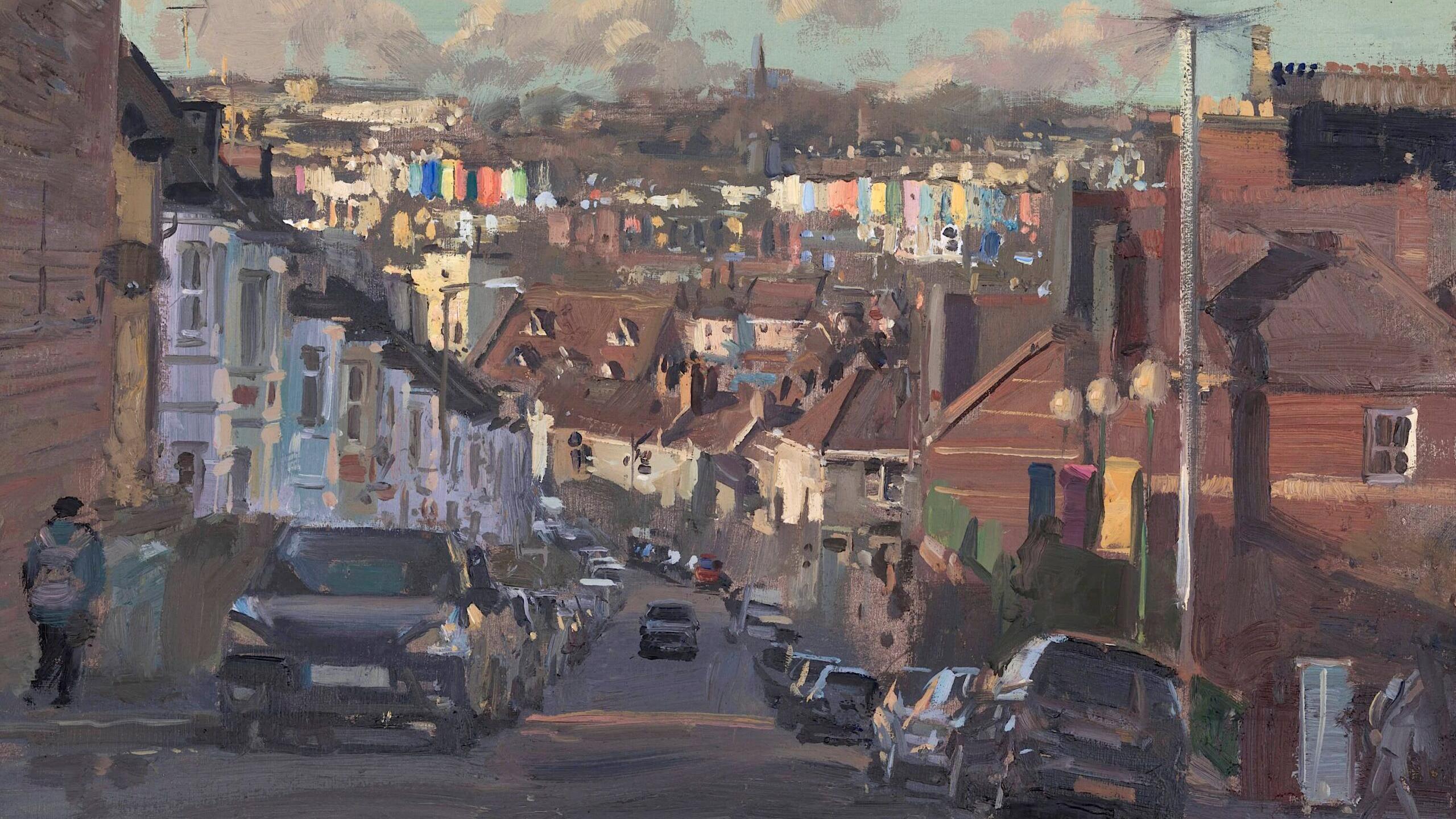 An oil painting of a residential street in Bristol. The road is steep and there are cars parked on either side of the road. The street is lined with houses. In the distance there are colourful houses. A person can be seen walking down the street.