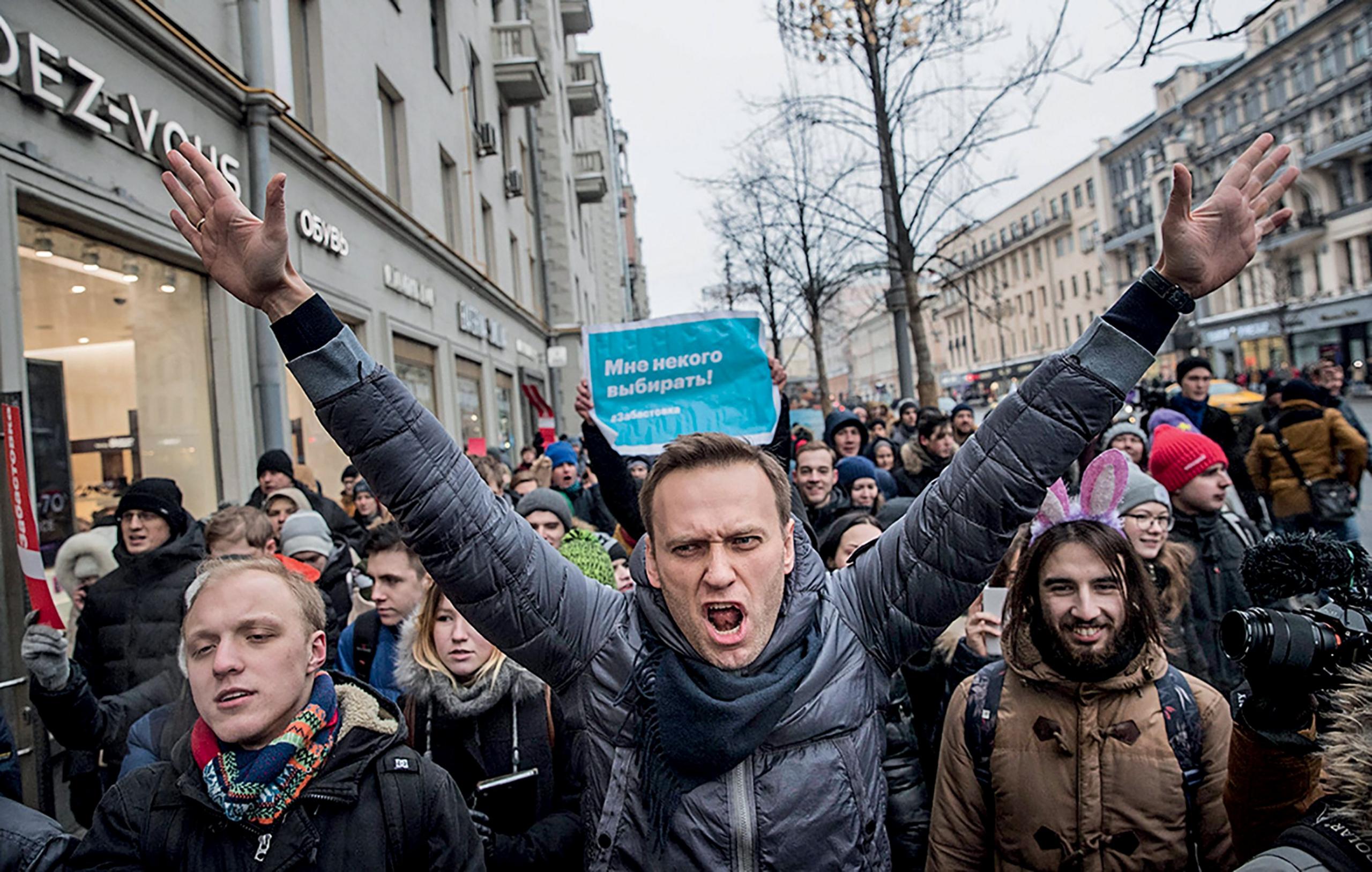 Alexei Navalny at a rally with his arms raised