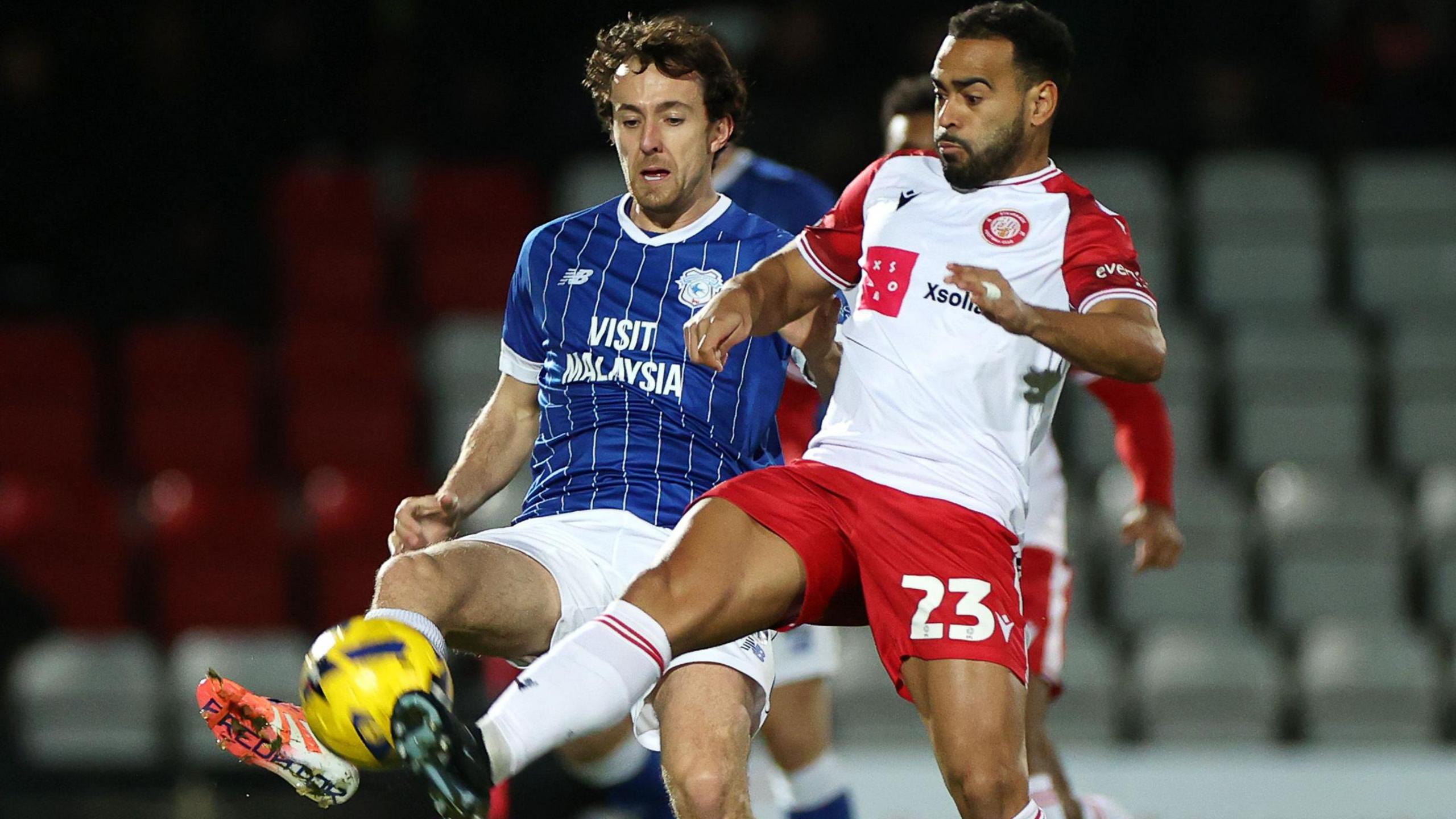 Louis Thompson of Stevenage is challenged by Ryan Wintle of Cardiff