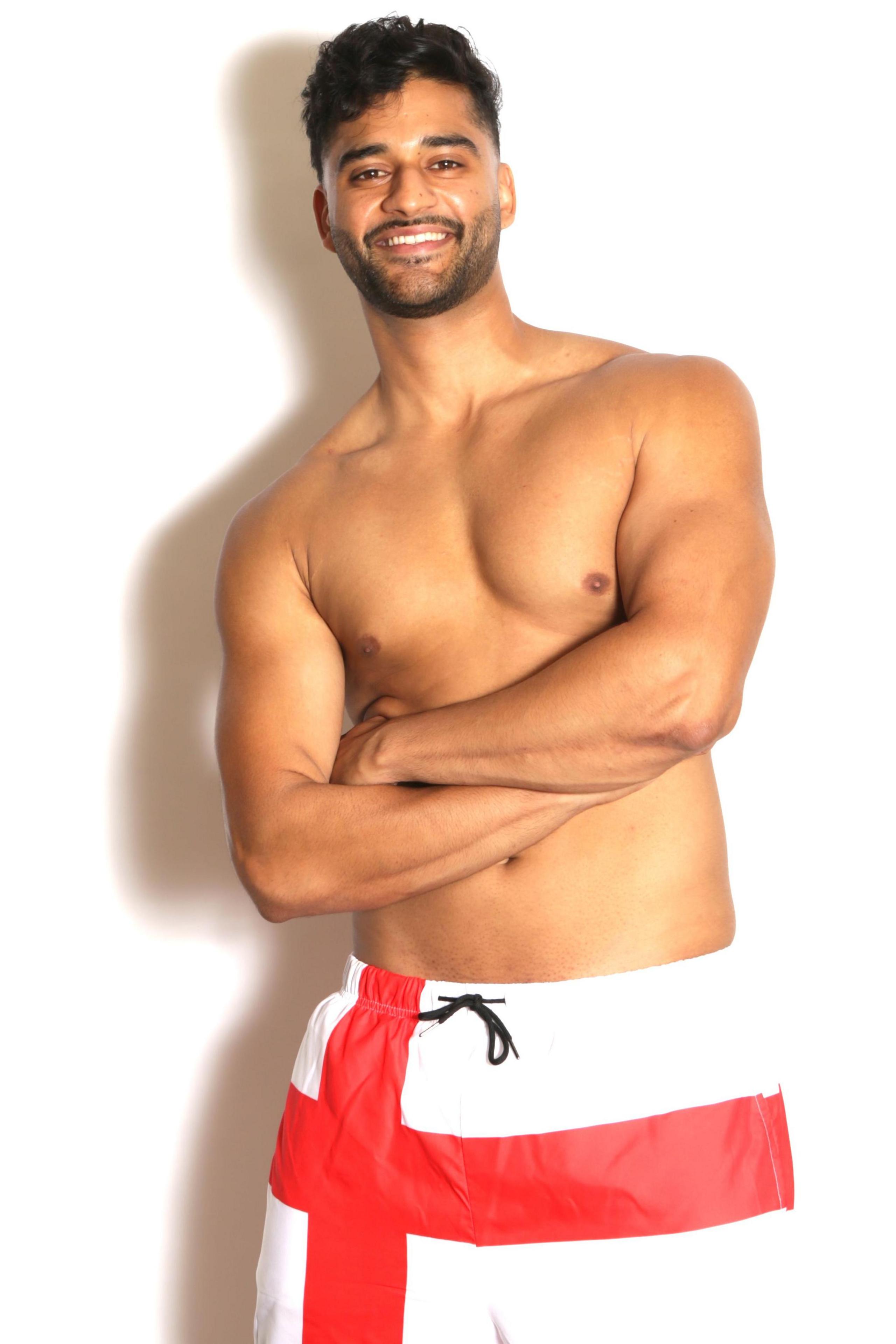 Bal is wearing shorts with the St George's cross on them. He is topless, folding his arms across his chest. He is and slim and toned and could pass for a Love Island contestant!