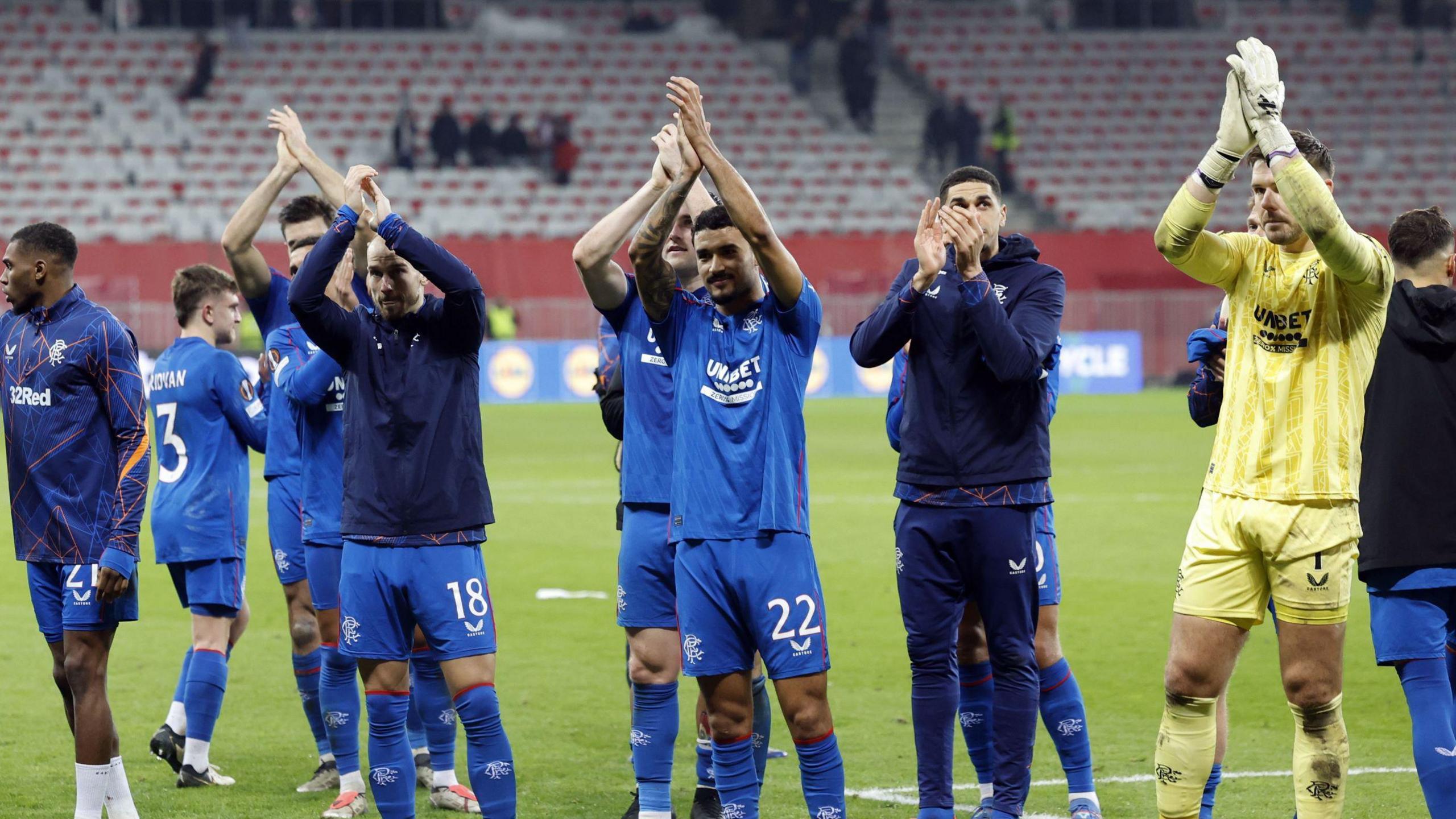 Rangers players celebrate their 4-1 win - several of the players, wearing their kit or training tops, are applauding fans after the match