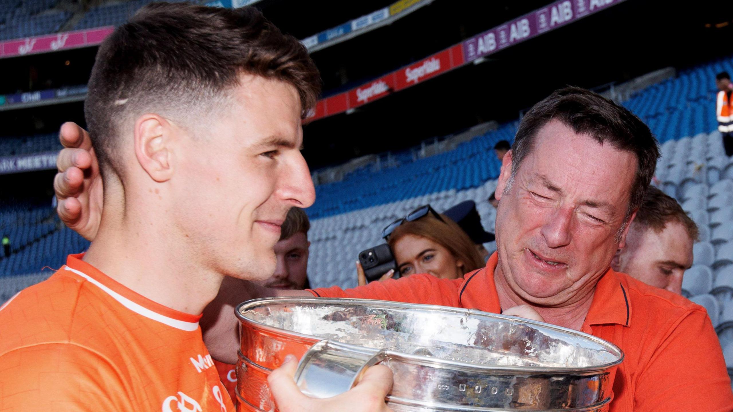 Niall Grimley hands the Sam Maguire to his father Brian