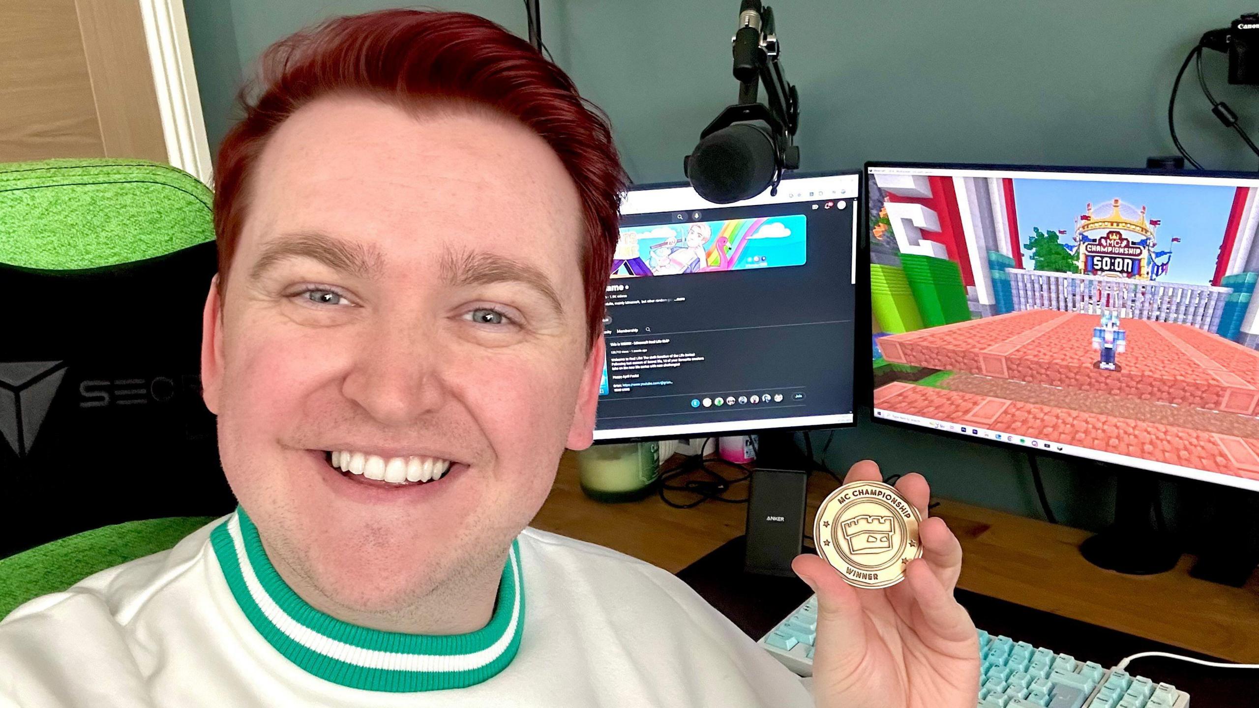 Scott Major holding up an MCC coin at his desktop setup