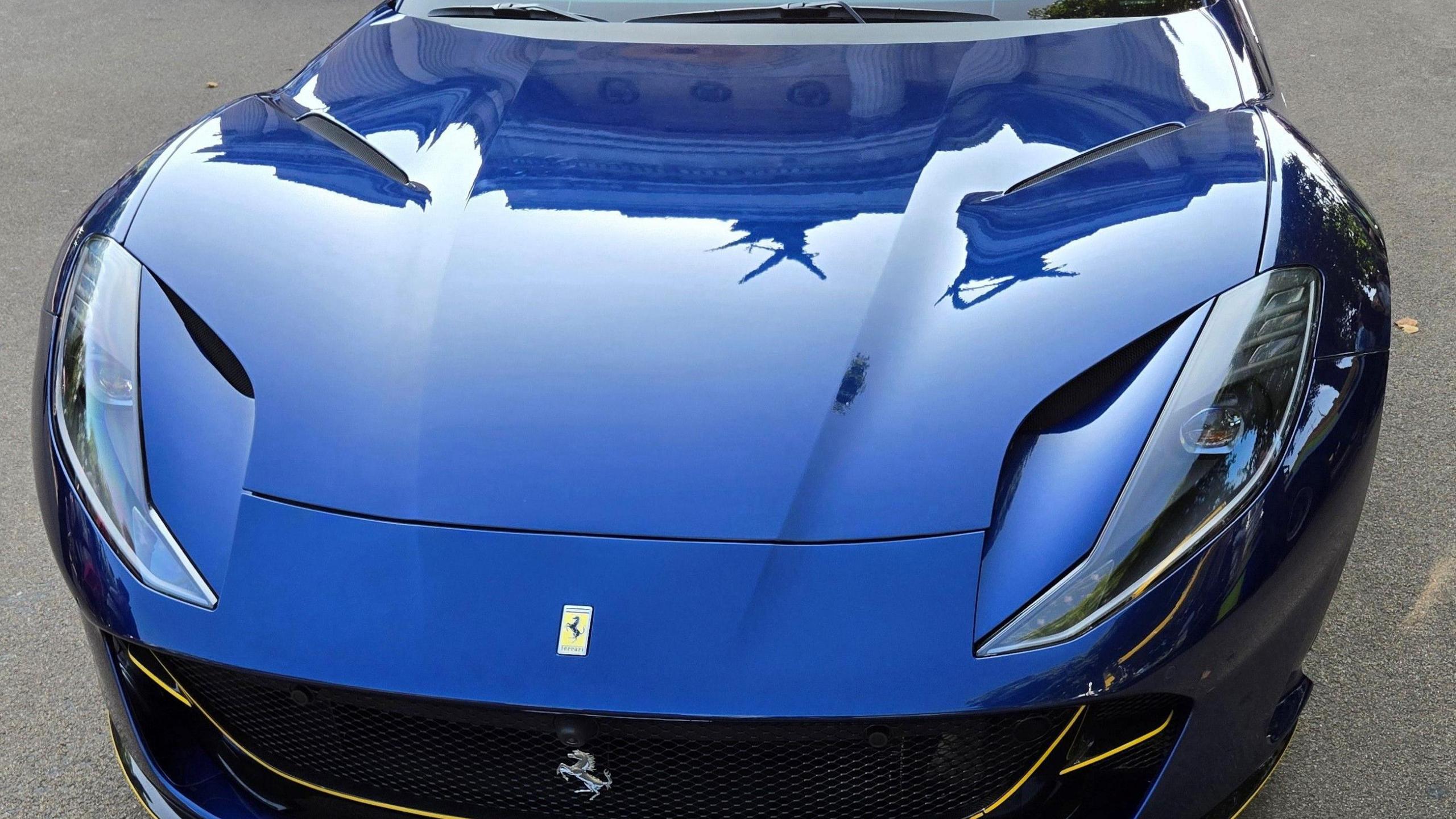 A close-up photo of a blue Ferrari's bonnet.