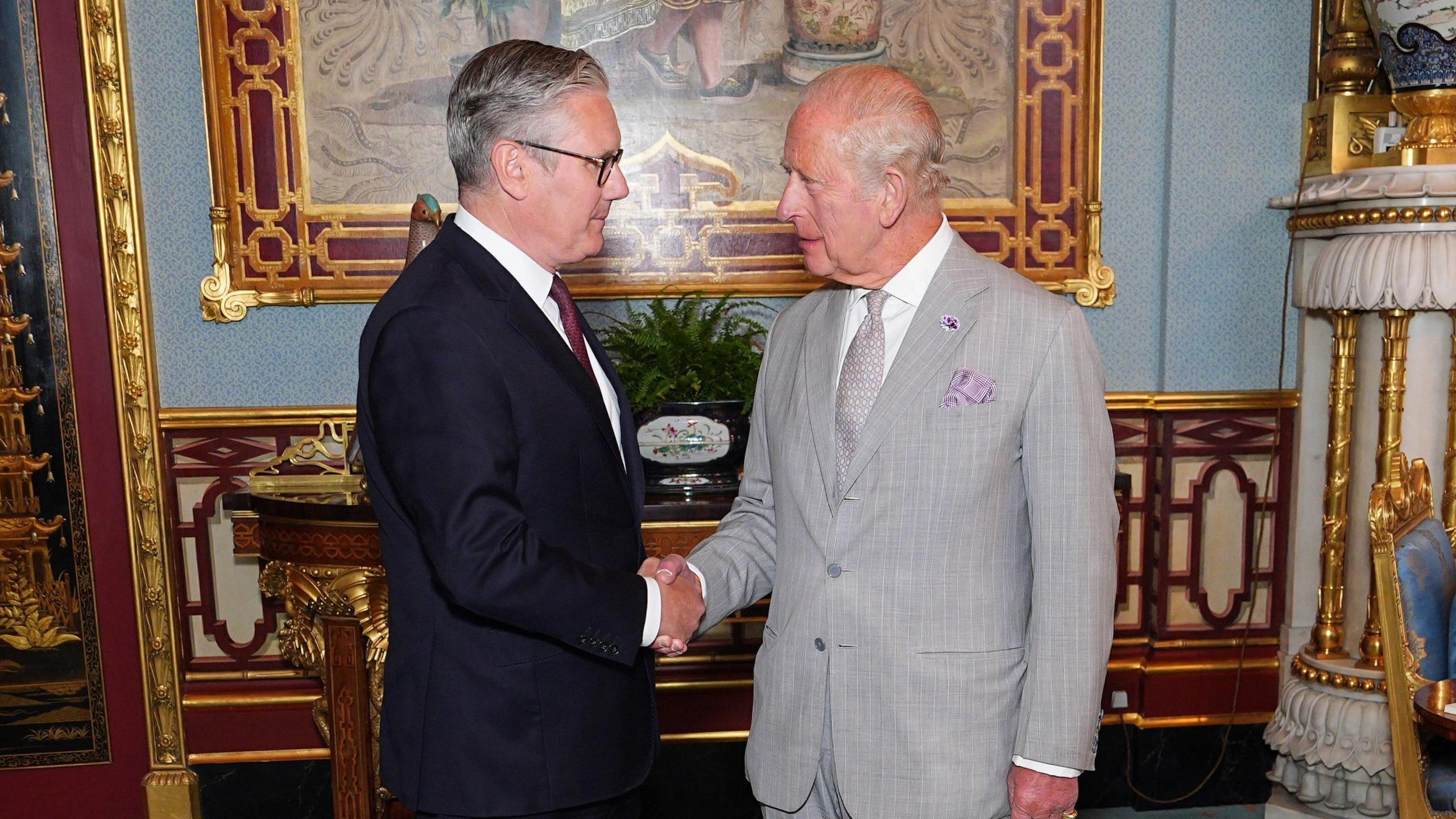 Sir Keir Starmer shakes hands with King Charles in an ornate room