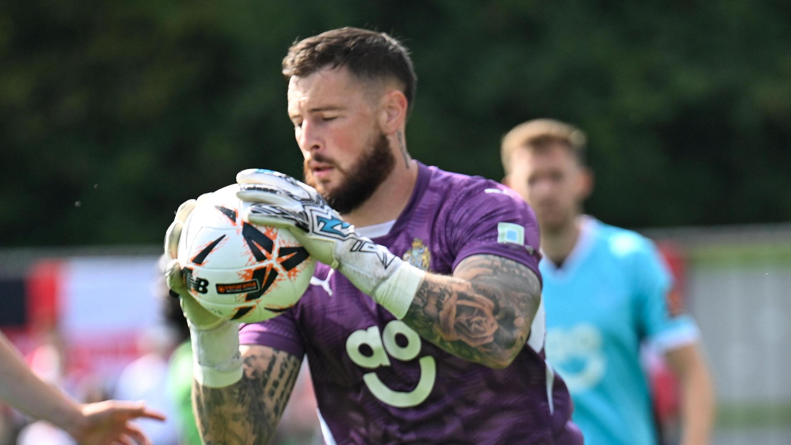 Ethan Ross, while in action for Altrincham, holding a ball with both hands in front of his chest