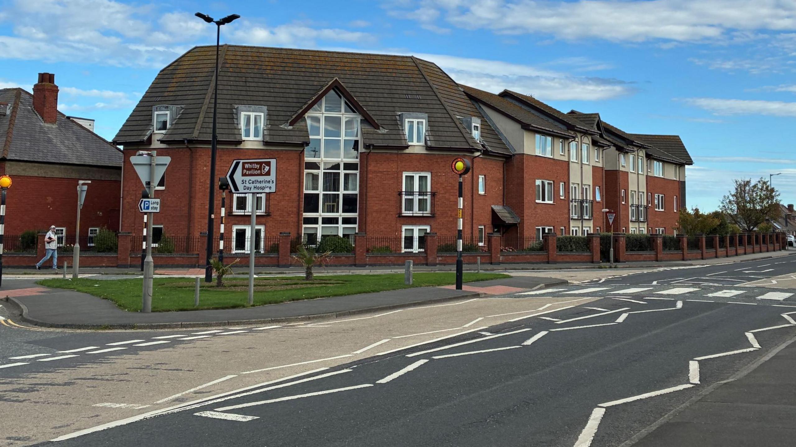 A three-storey flat block positioned against a road.