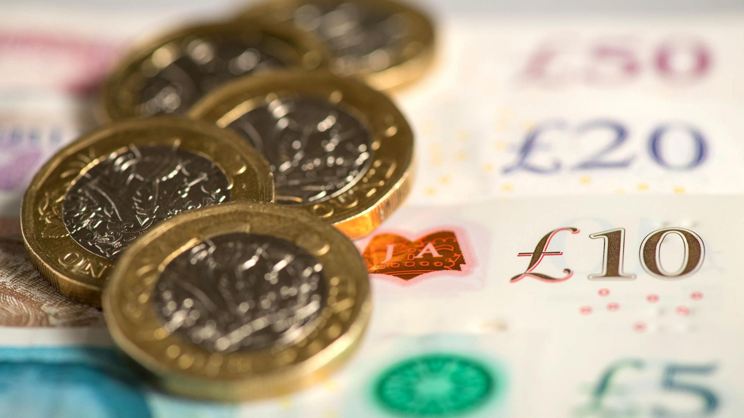 A close up on £1 coins and various banknotes