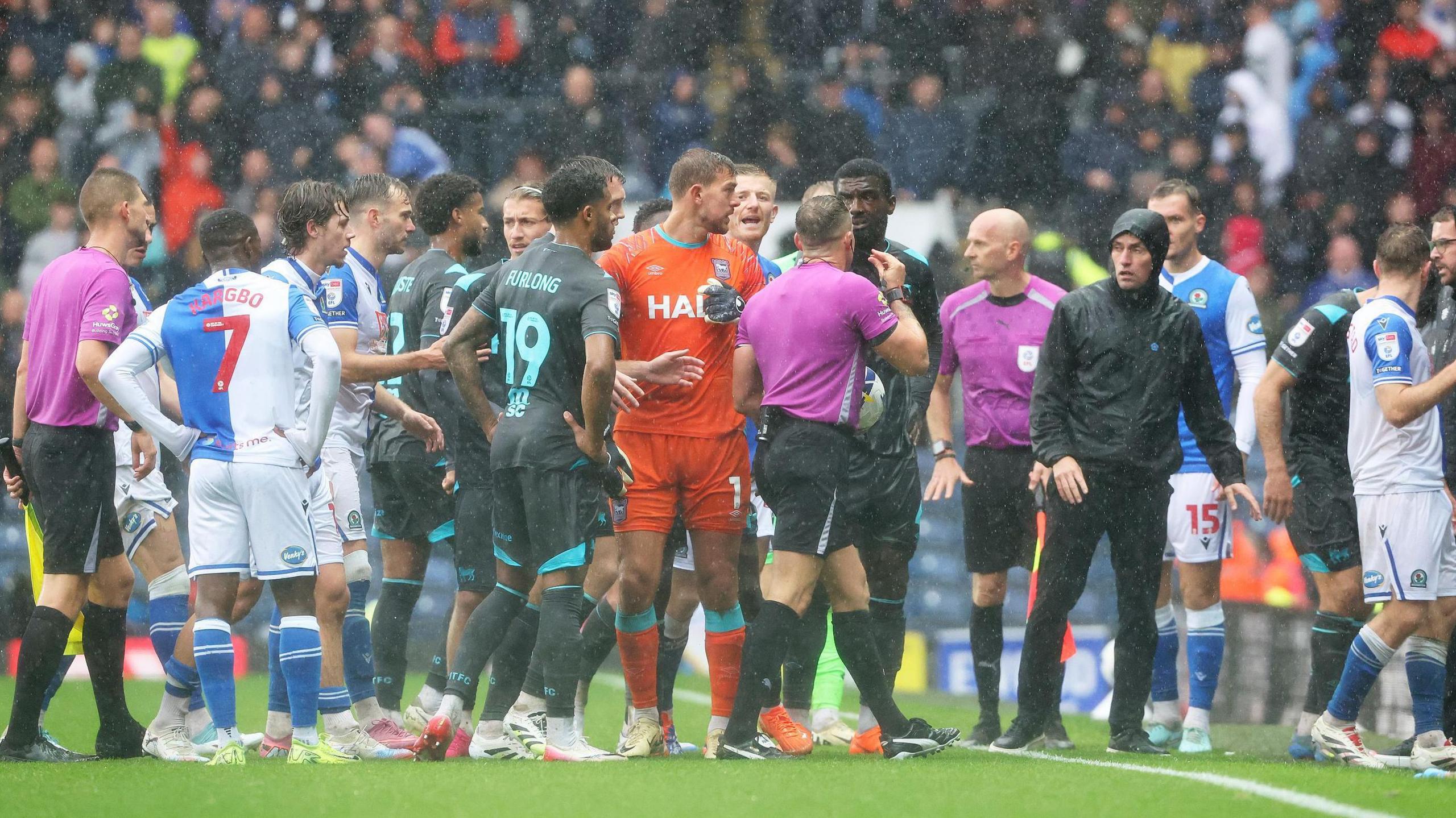 Referee Steve Martin consults with the players as Blackburn Rovers' game with Ipswich Town succumbed to heavy rain