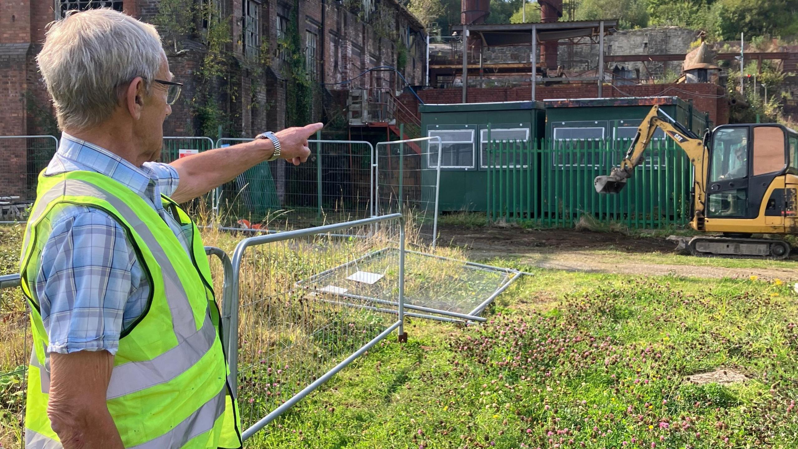 Former employee Colin Davies points at construction work on the steelworks site