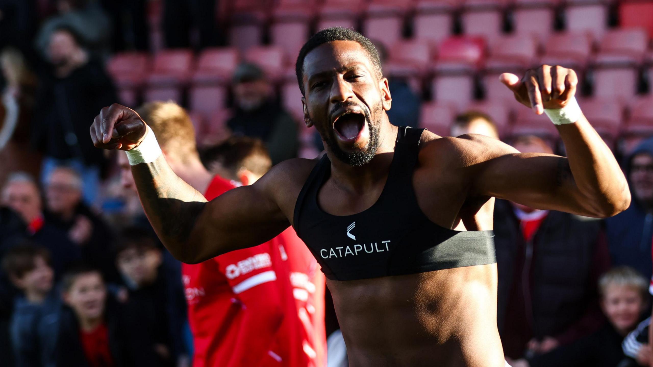 Omar Bogle takes his shirt off in celebration after scoring for Crewe
