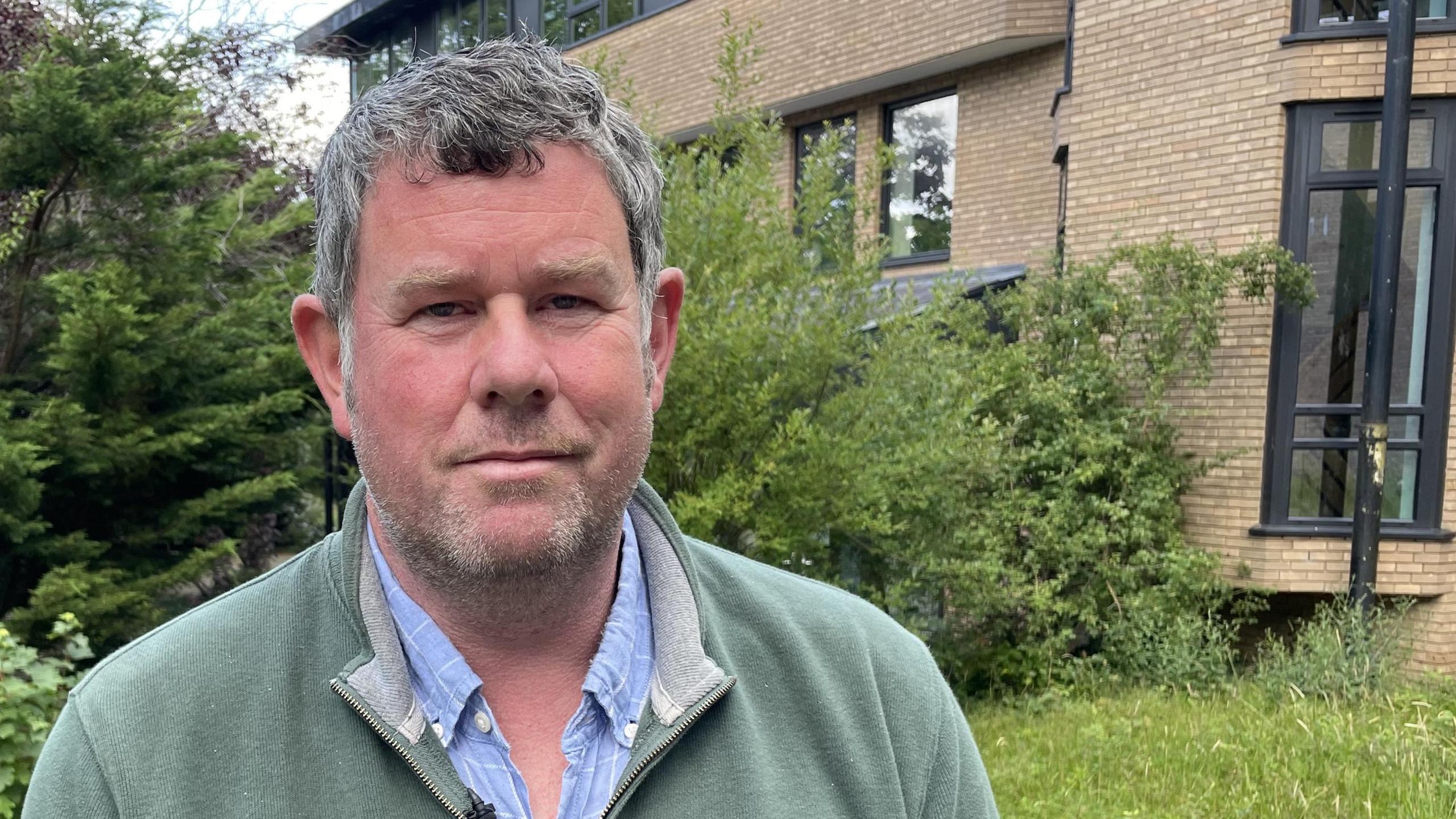 Dylan Williams, of Natural Resources Wales, standing outside with offices in the background