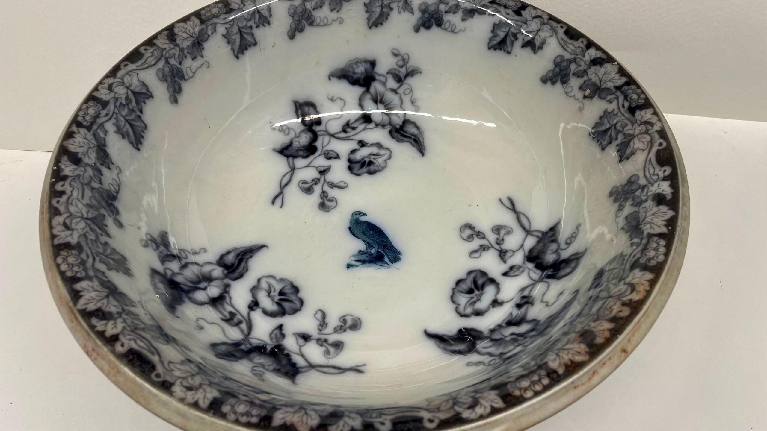 A professional image of a white serving bowl with an intricate dark blue floral and bird pattern