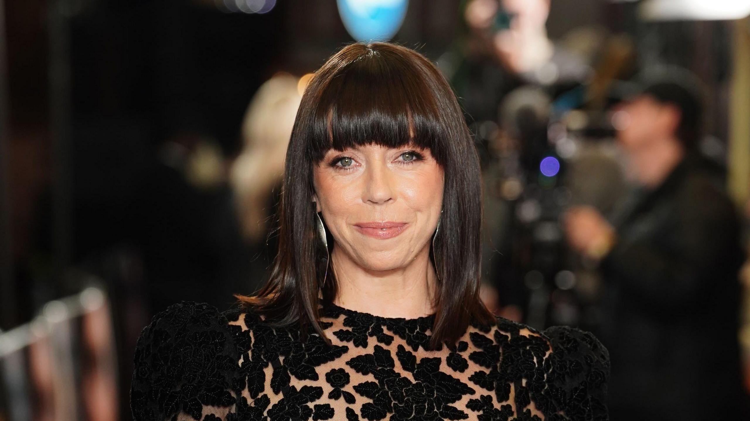 Eileen Walsh on the red carpet. She has shoulder-length brown hair and is wearing a black dress