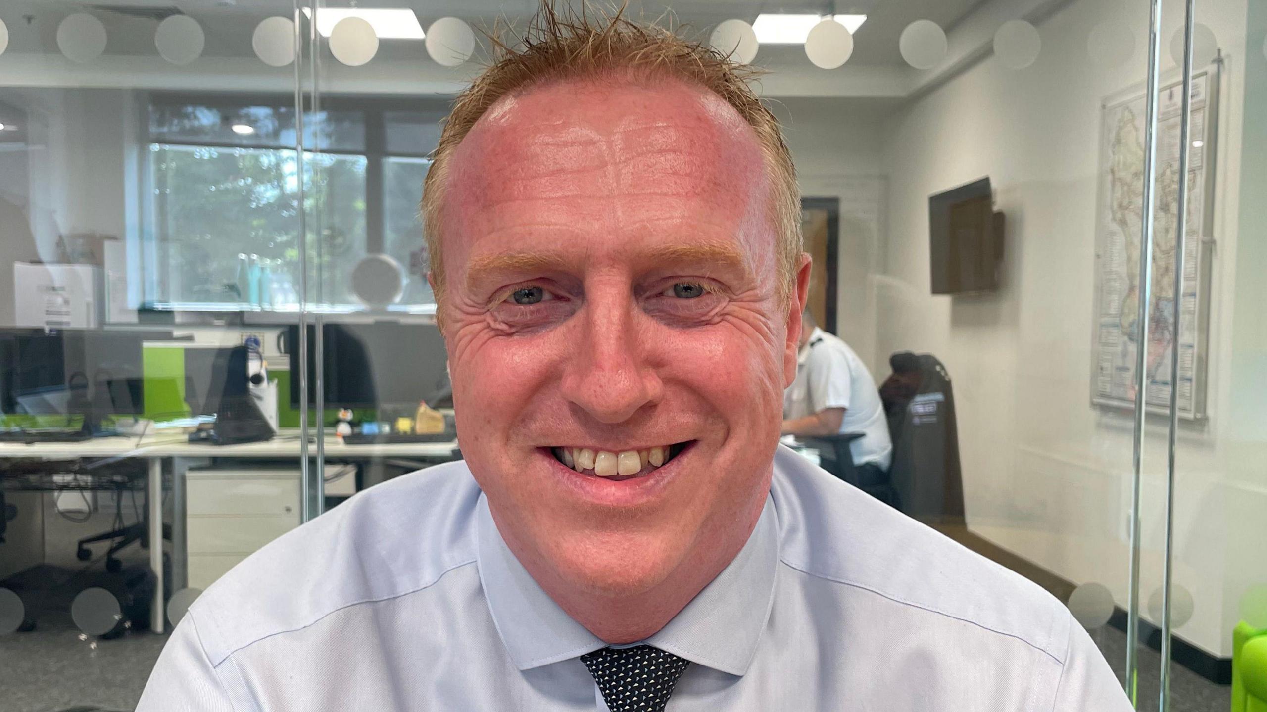 Ian Green is wearing a light shirt and dark tie