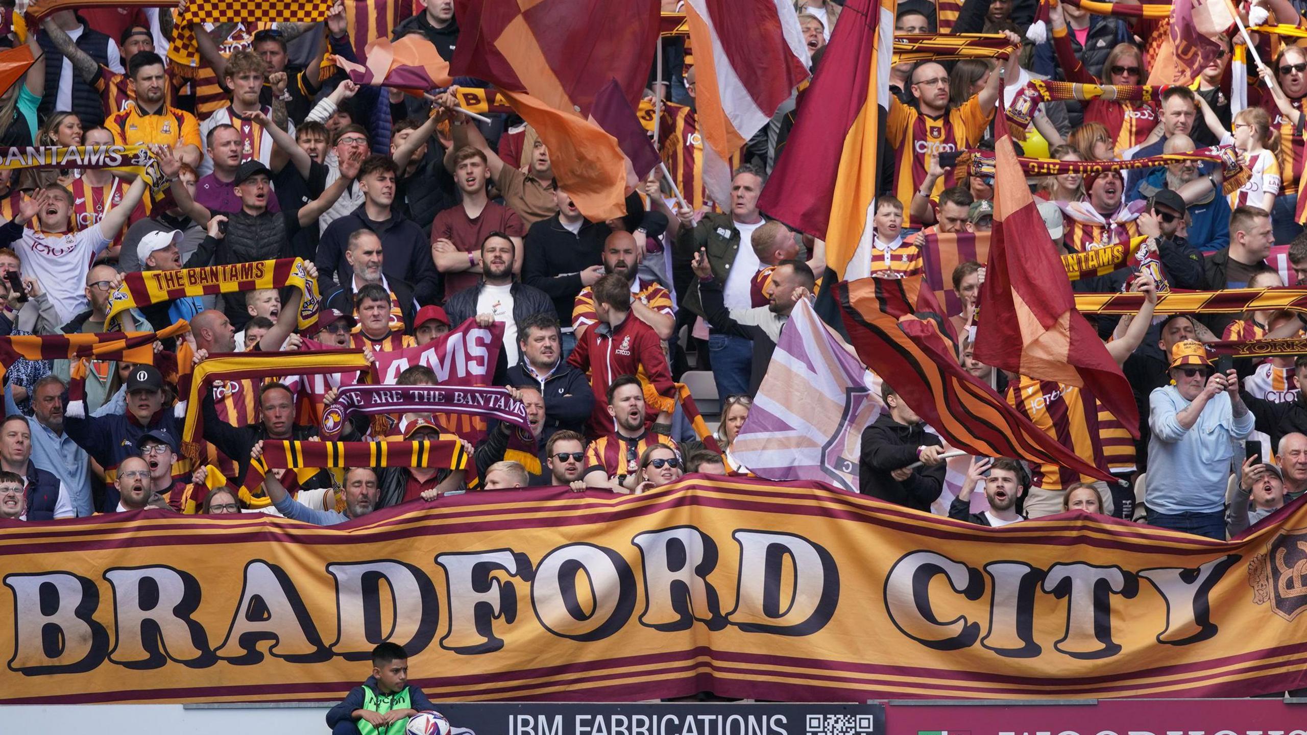 Bradford City fans in the stands before their final game against Fleetwood with a banner with the football club's name across it