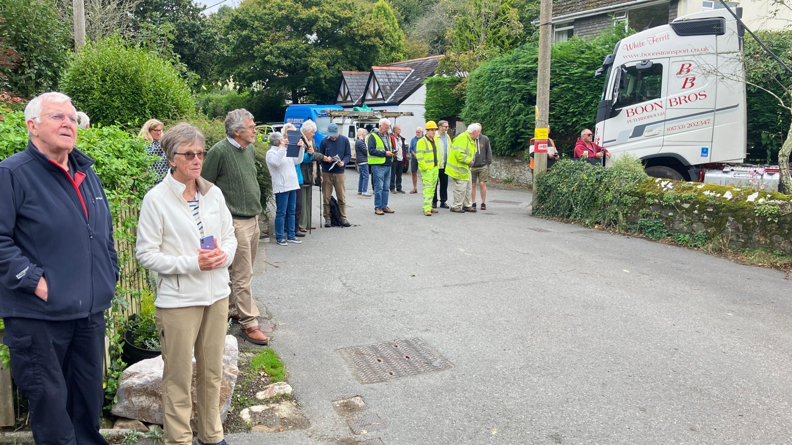 Residents in the street watching the removal of the lorry