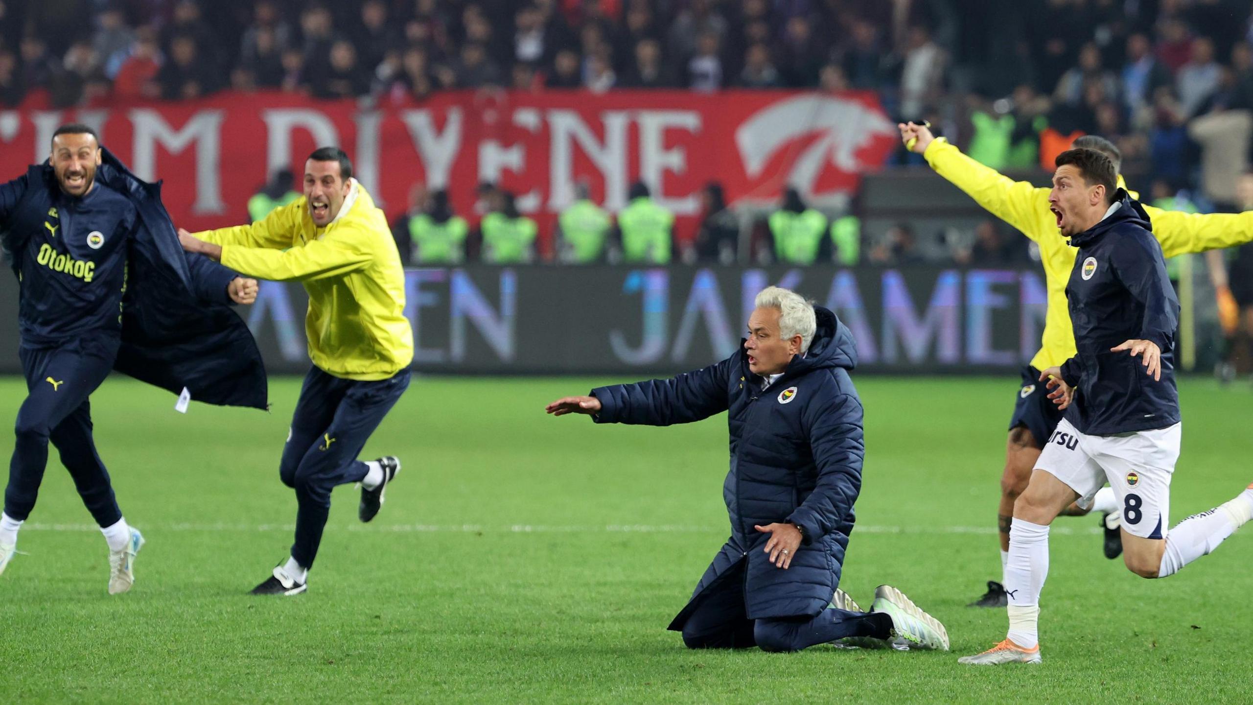 Fenerbahce boss Jose Mourinho tries to do a knee slide after his side's win at Trabzonspor