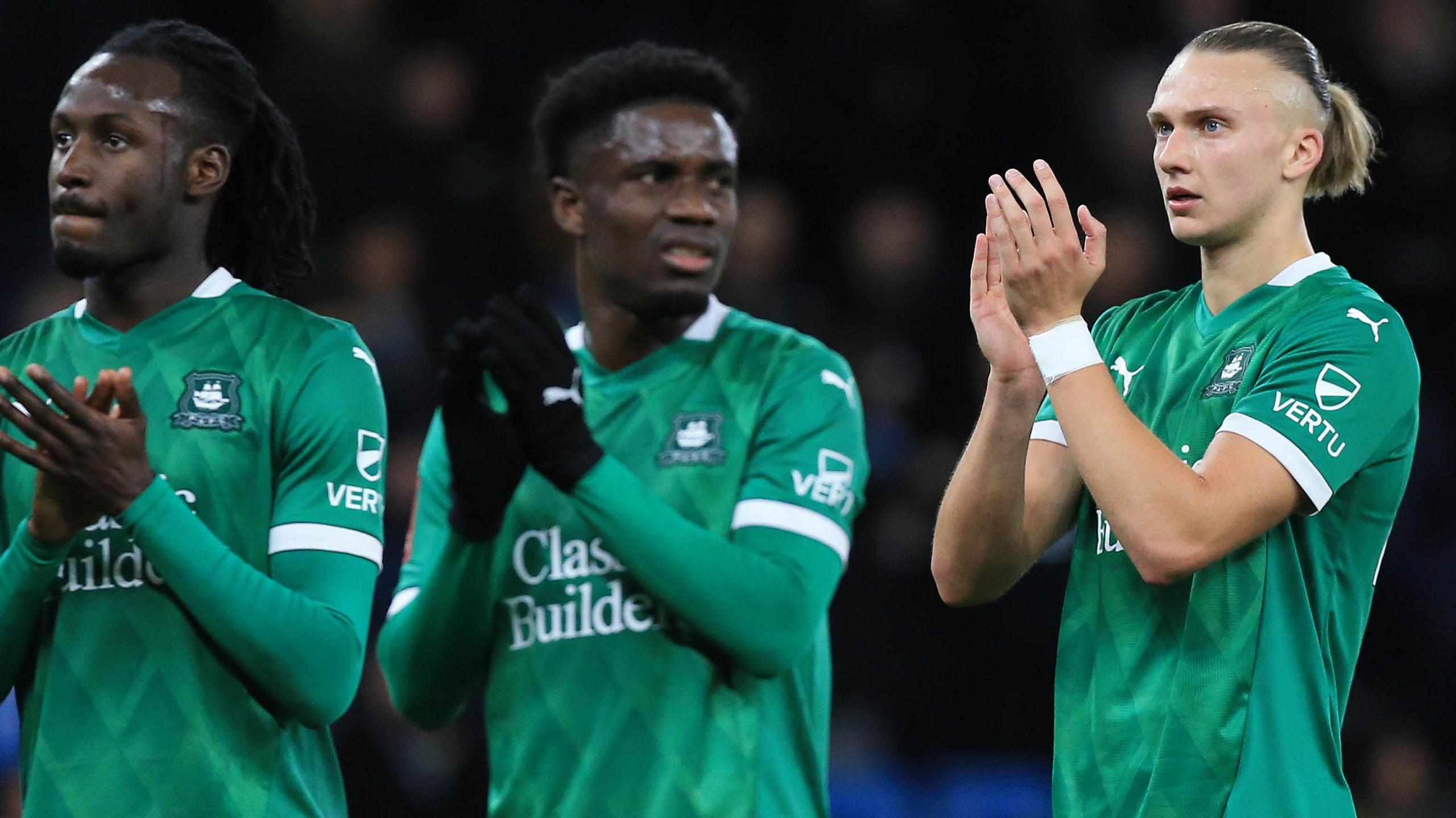 Plymouth Argyle players applaud the crowd after their loss at Manchester City