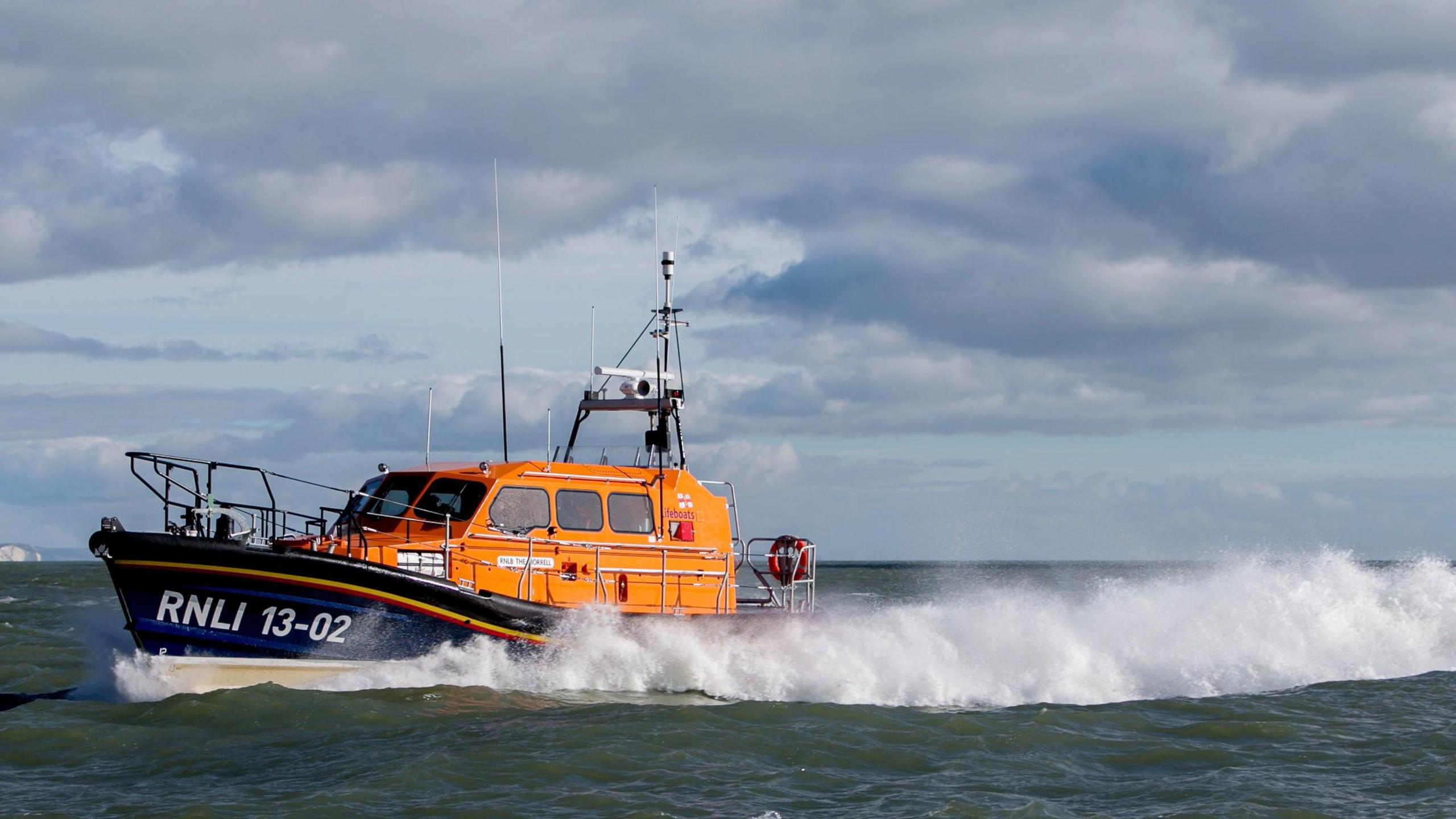 An orange and navy RNLI lifeboat in the sea (stock photo) 