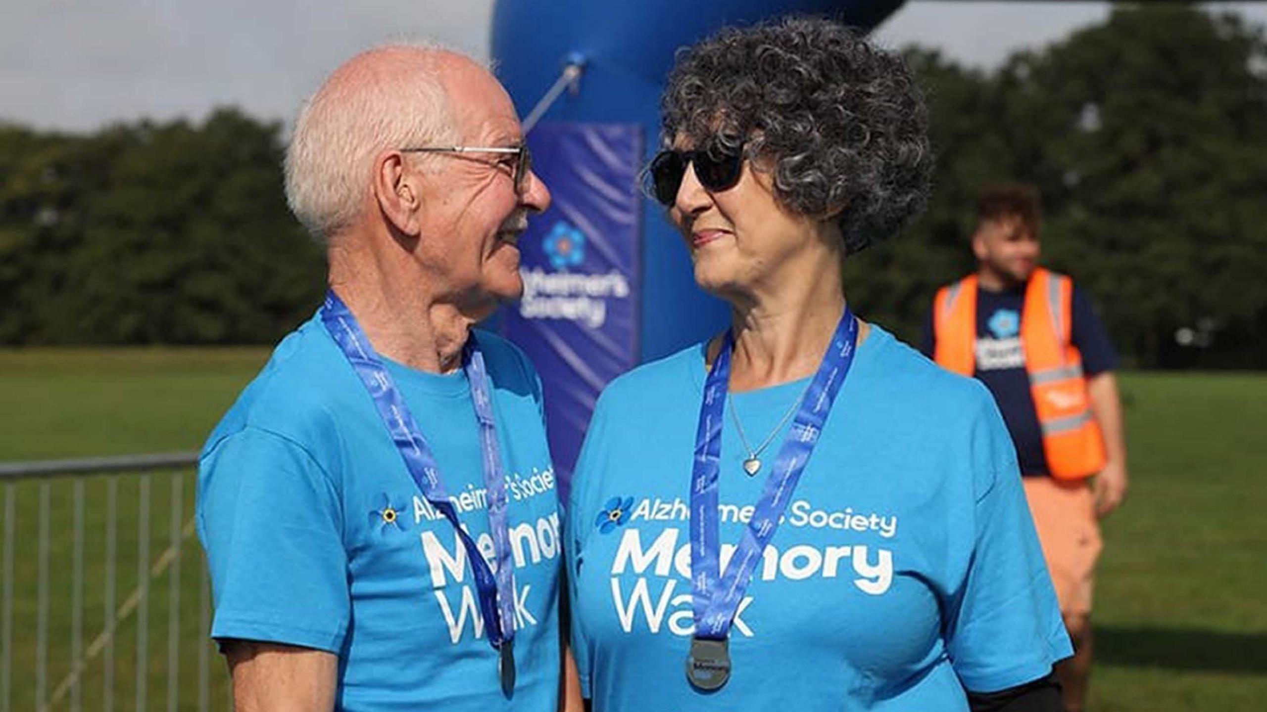 Brain and Elaine Windass at the Alzheimer's Society memory walk, they wear matching branded t-shirts and medals at the finish line.