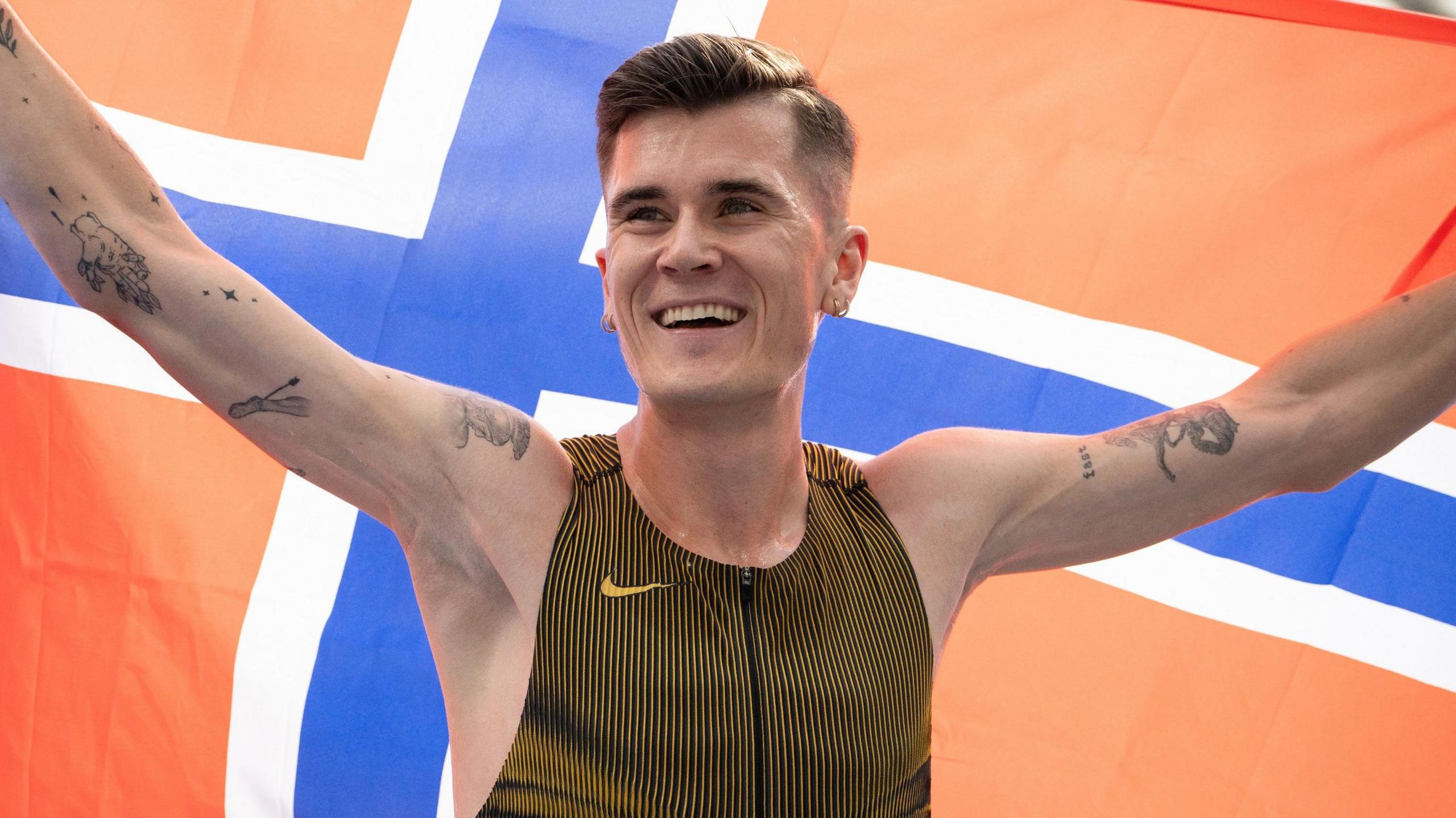  Jakob Ingebrigtsen celebrates by holding aloft the flag of Norway