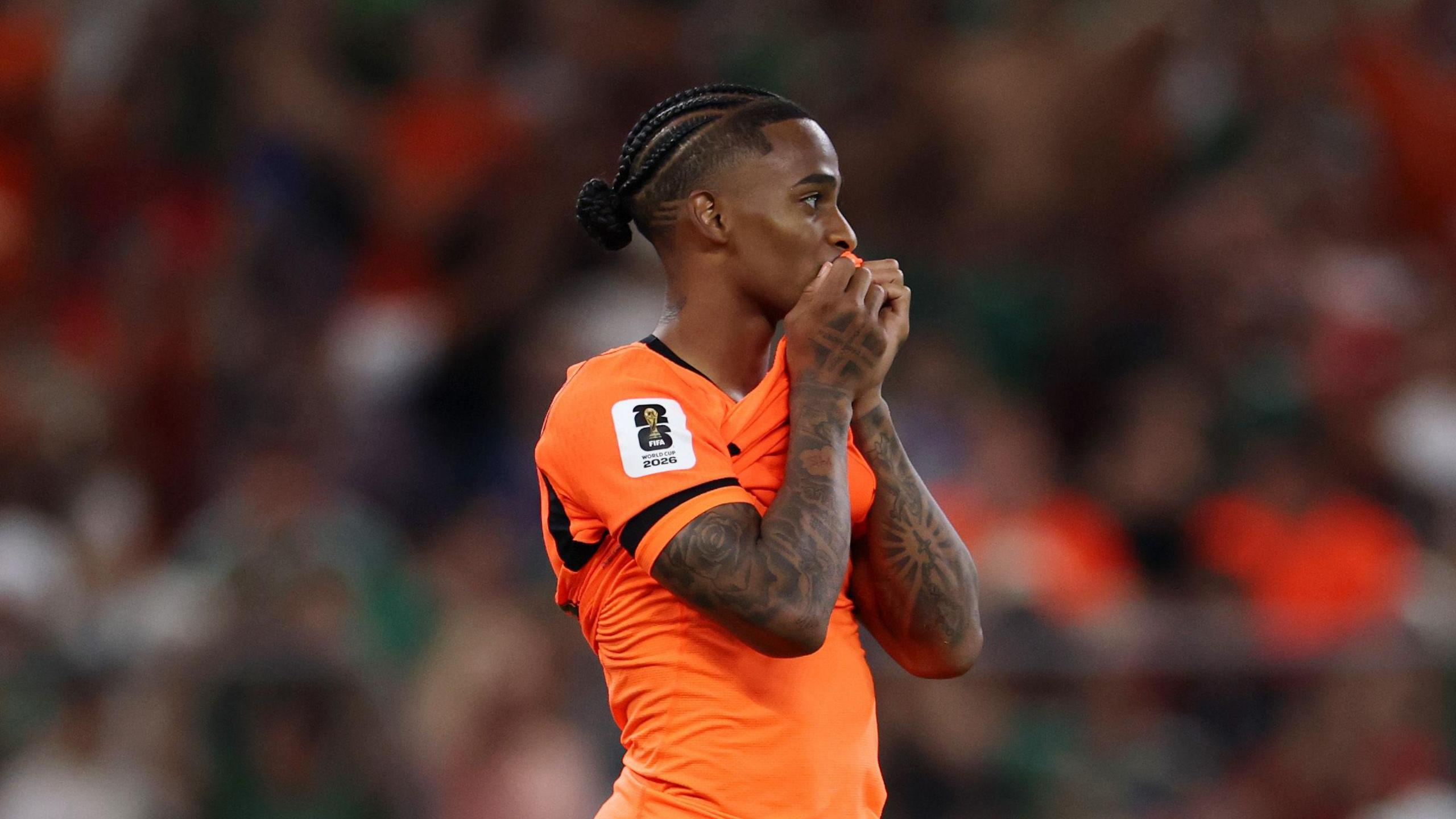 A photo of Crysencio Summerville, wearing his orange Netherlands kits, holding his shirt to his face after his penalty is saved against Morocco on Tuesday.