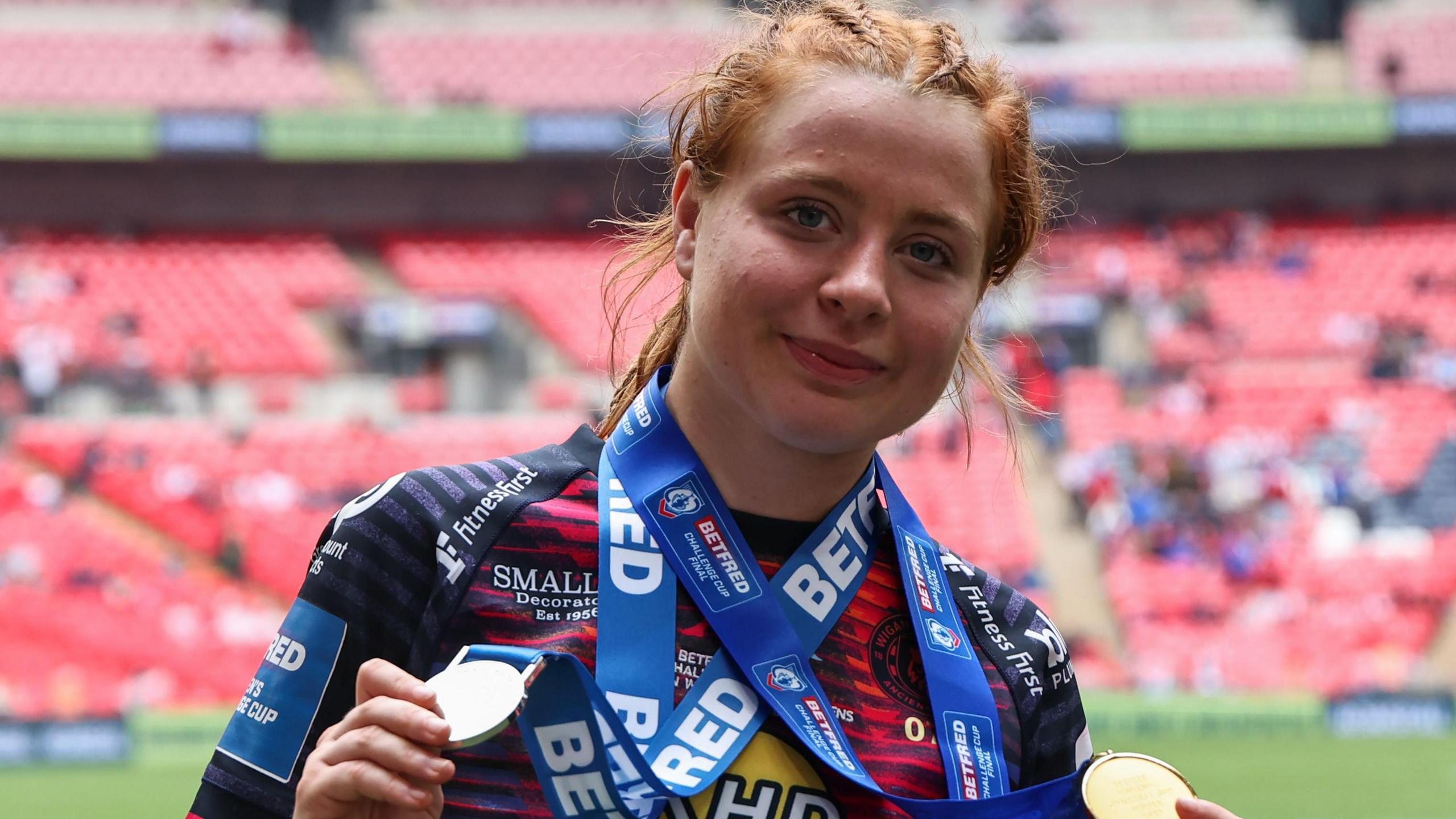 Grace Banks holds up her Women's Challenge Cup final winners and player of the match medals